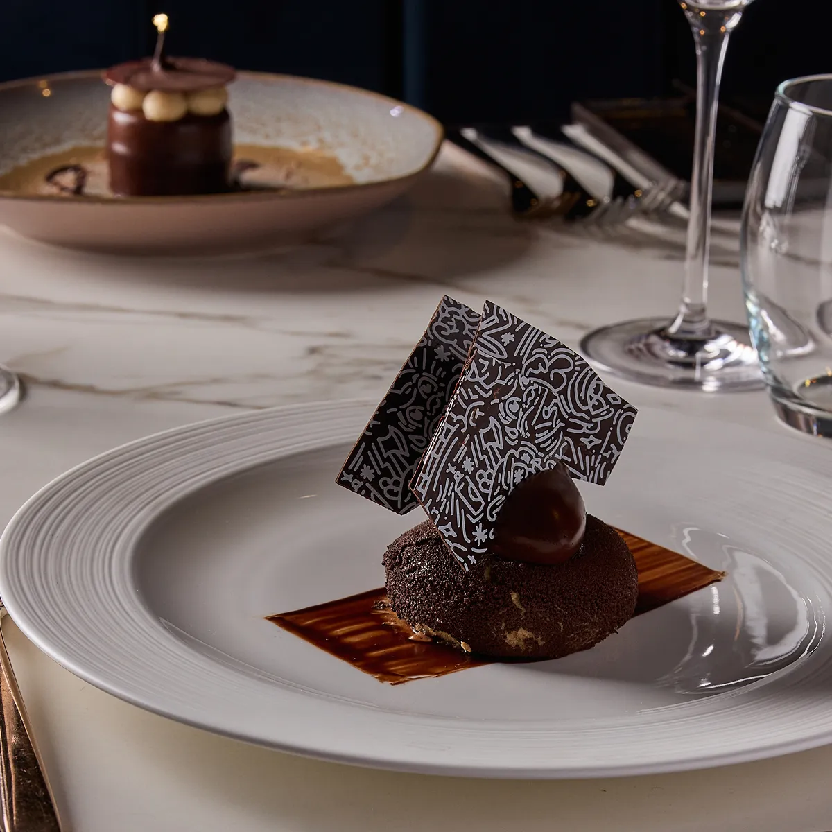 2 desserts on a table in a high end restaurant.