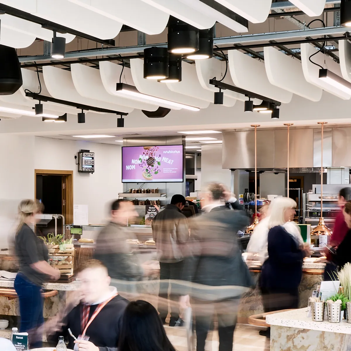 An action shot of a busy cafe with the people moving.