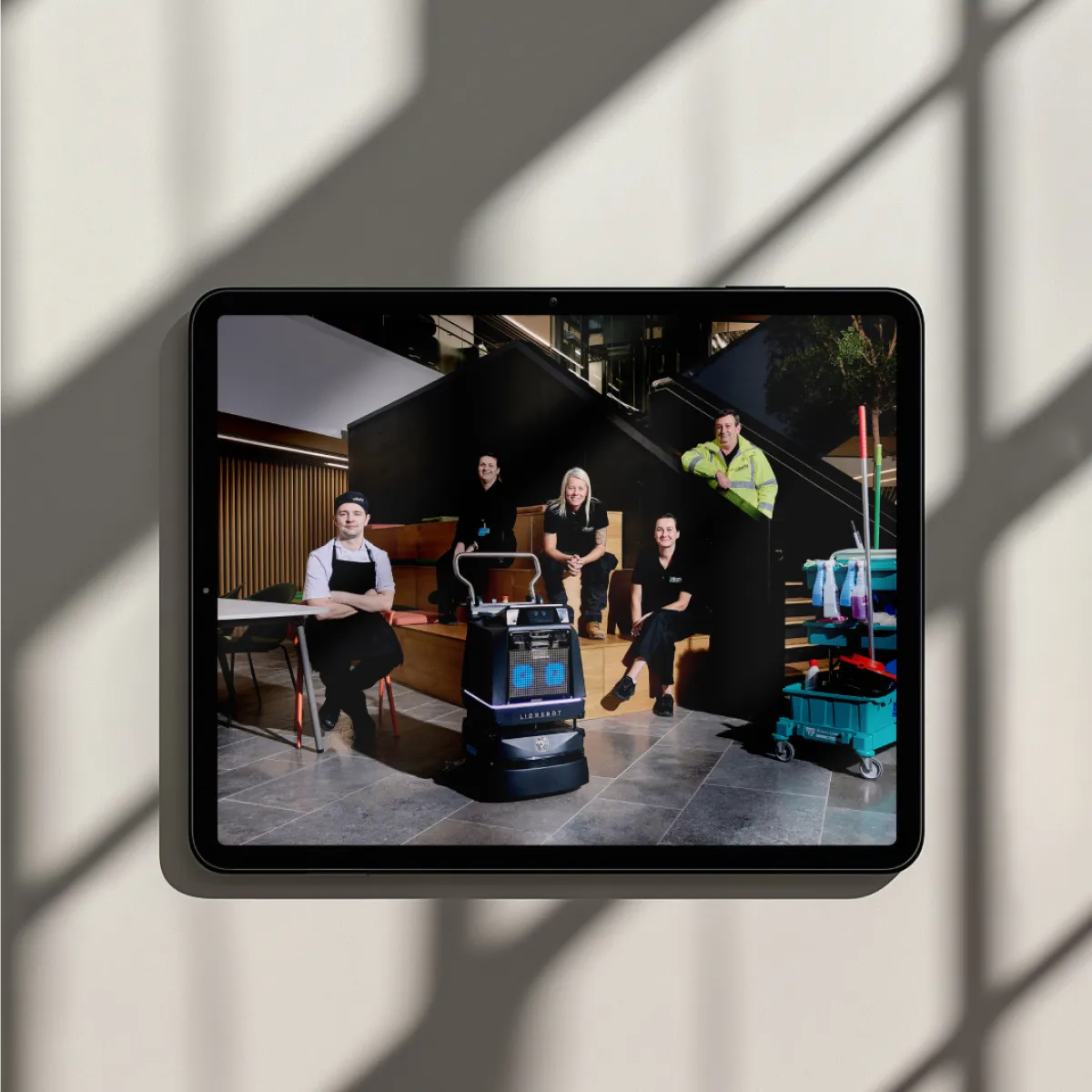 A team in a relaxed setting with the image highlighted on a screen.