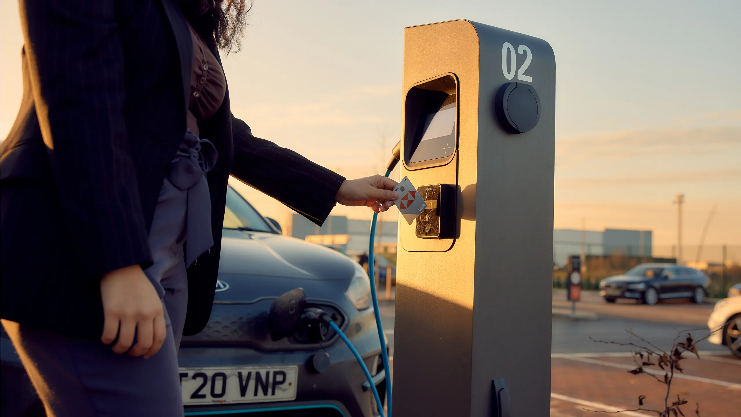 A person charging their vehicle in a car park.