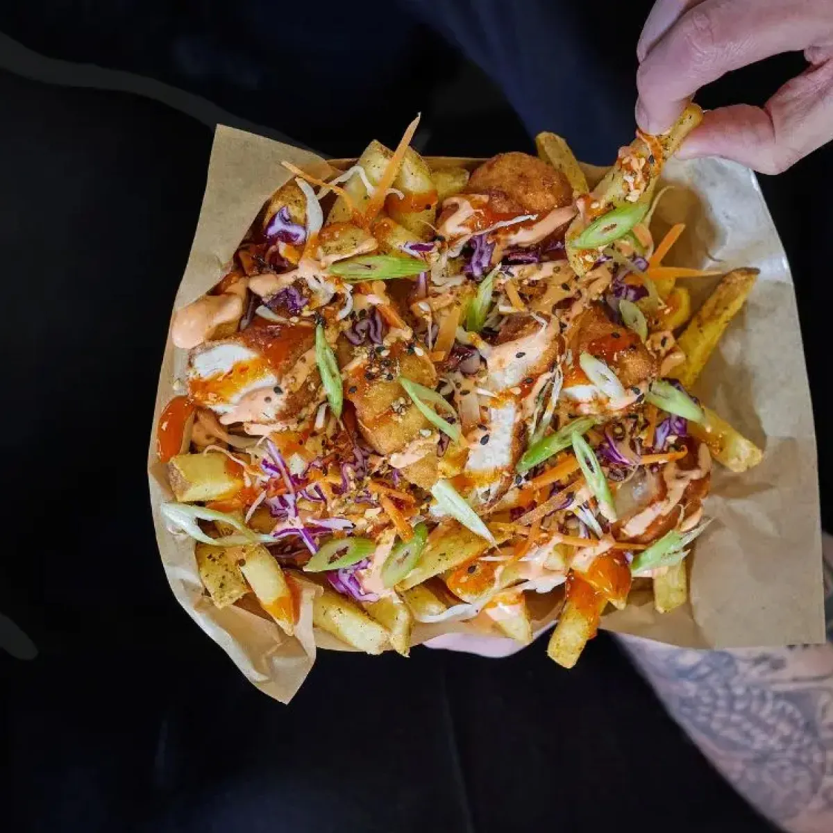 Loaded fries with lots of sauce, chicken and spring onions.
