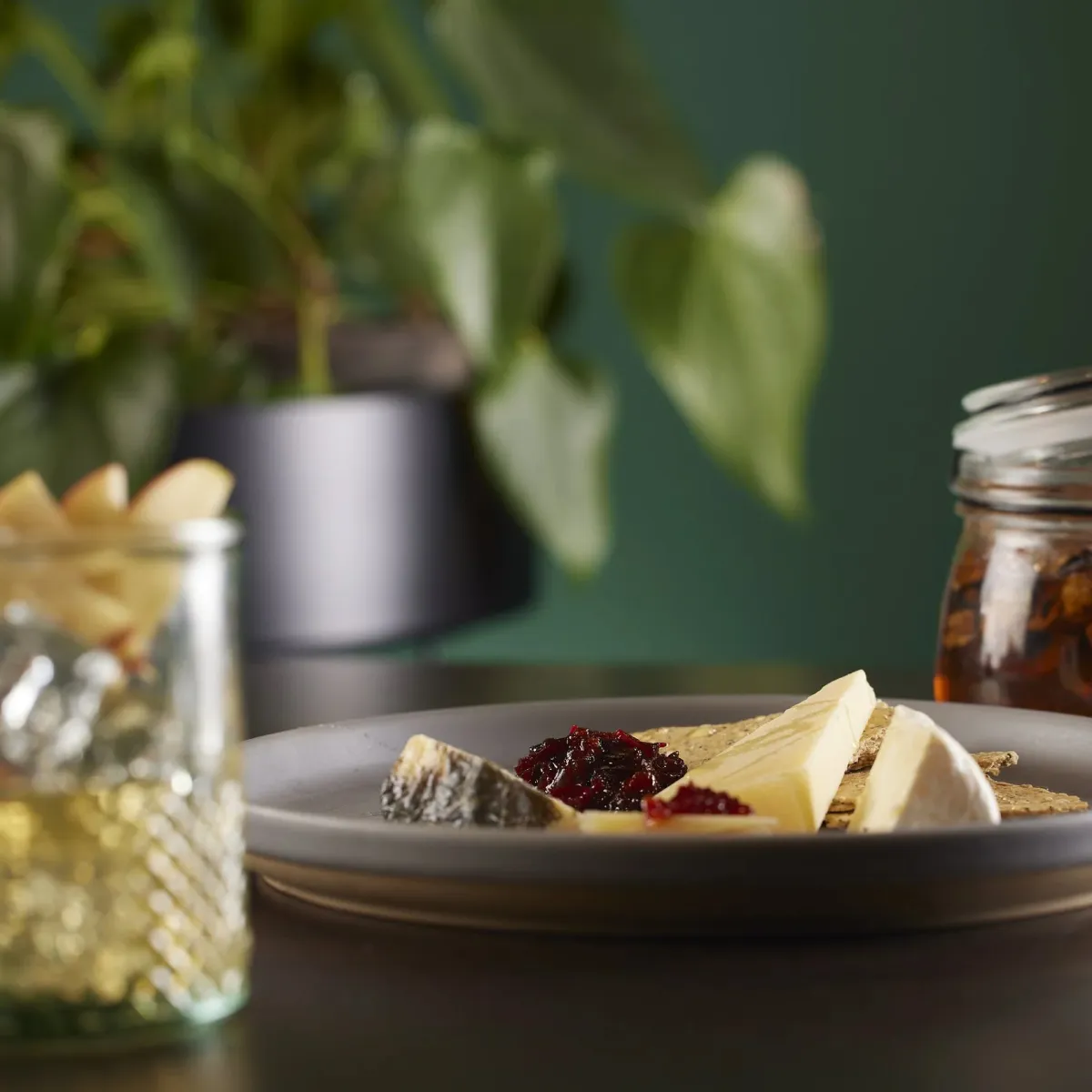 A delicious cheeseboard in front of a calming background.