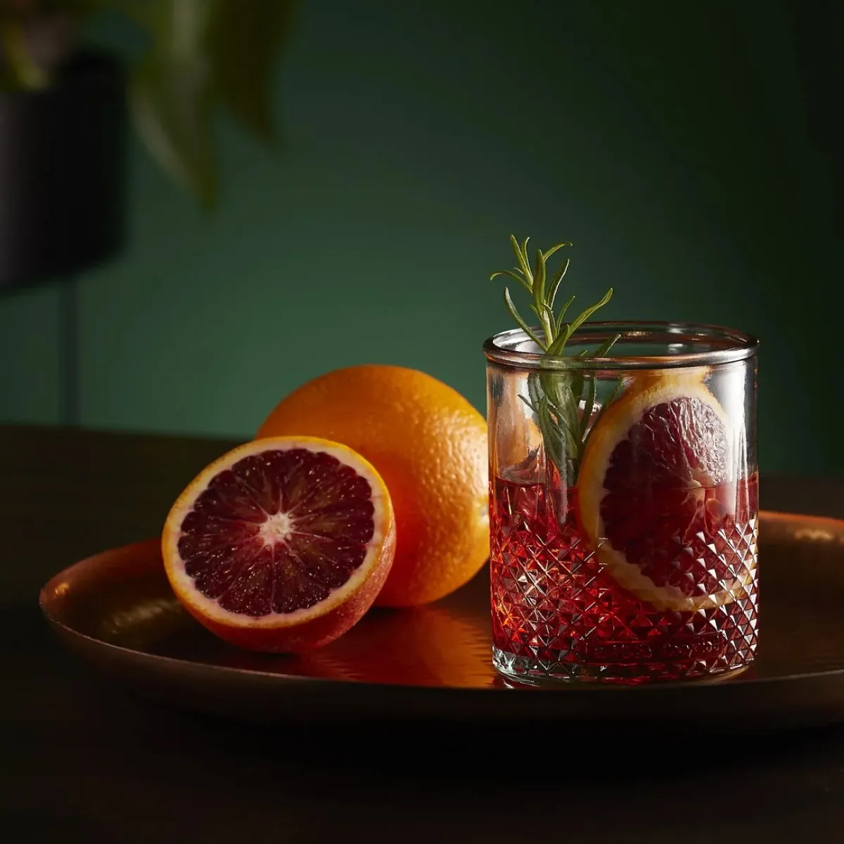 A delicious looking cocktail with a green background with gold detailing.