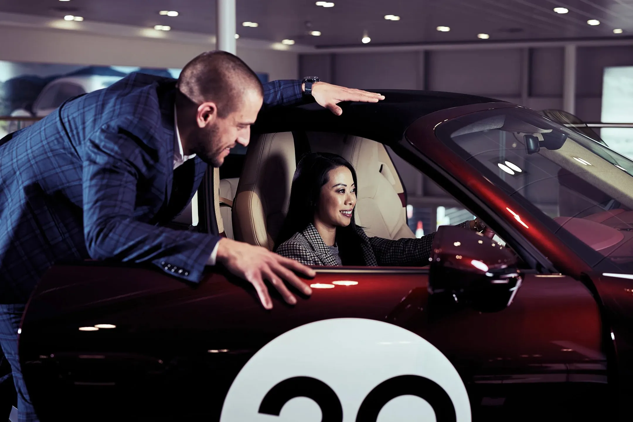 Female with a member of the Sytner team looking at a car