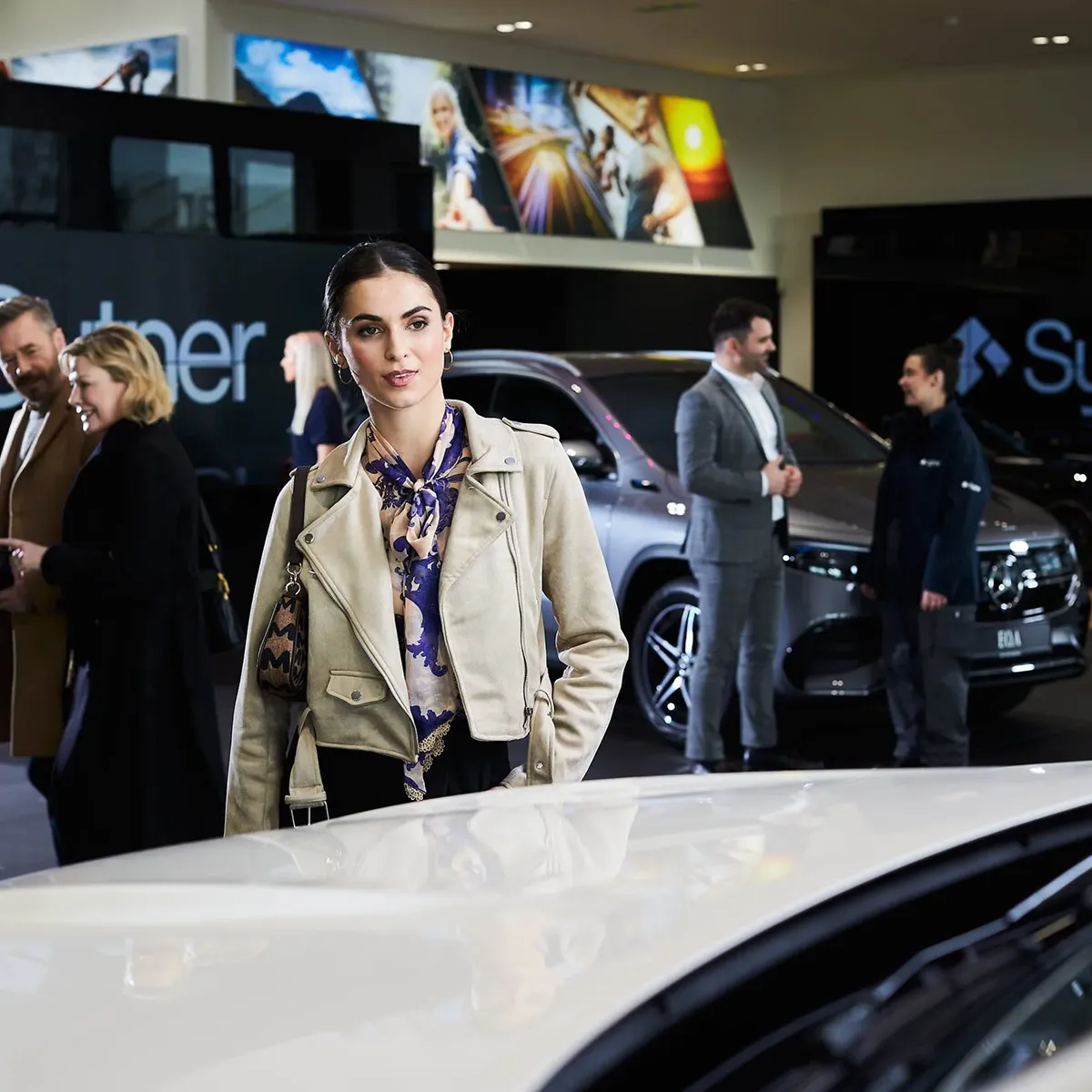 Female in a Sytner showroom with other customers in the background