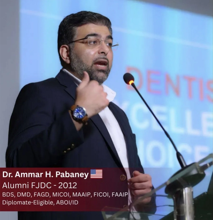 Dr. Ammar H. Pabaney speaking at a podium with a microphone, wearing a dark suit and glasses.