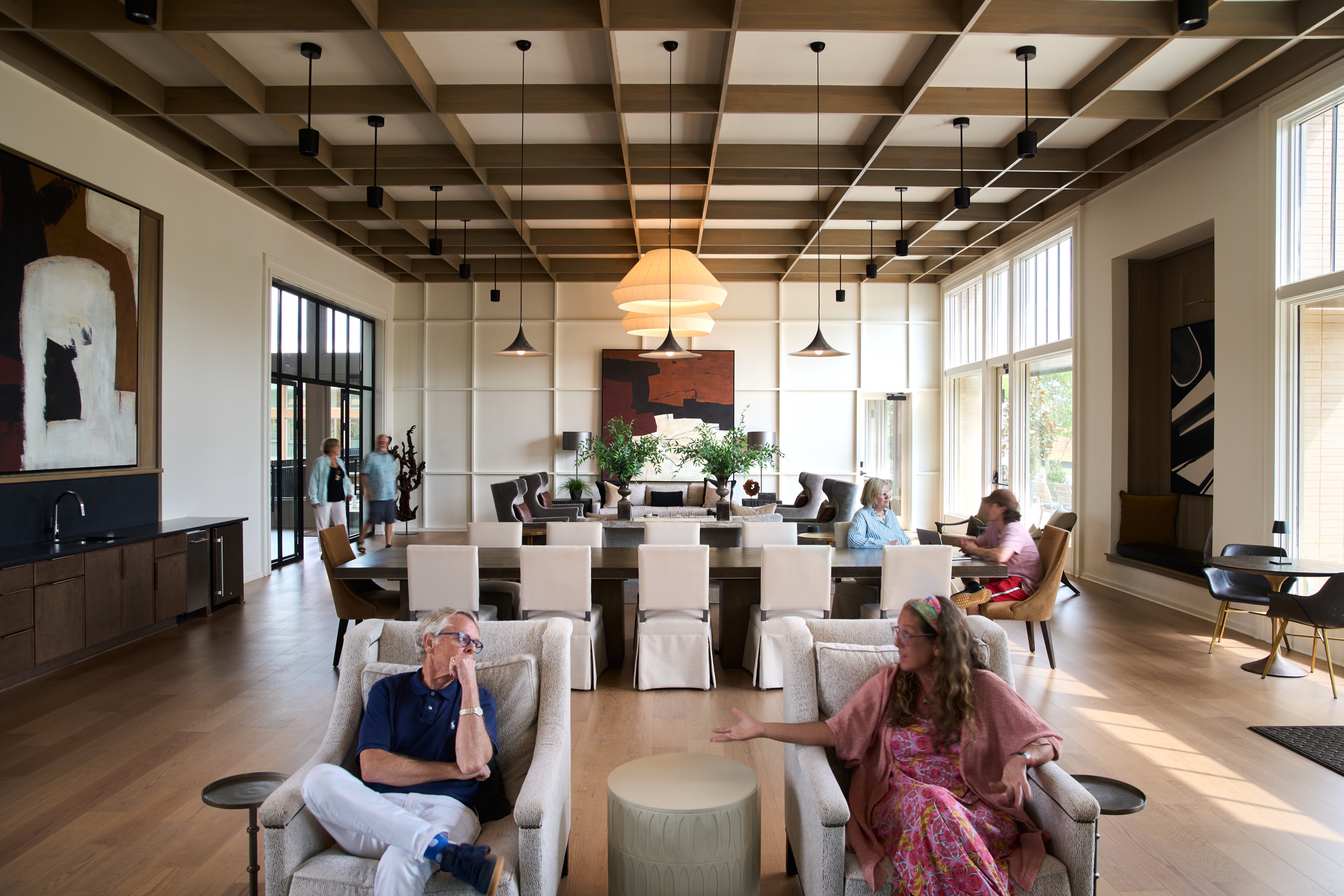 Great room lounge at the Everlee Clubhouse with residents seated beneath a coffered timber ceiling, photographed by Omar Mohammad Studio