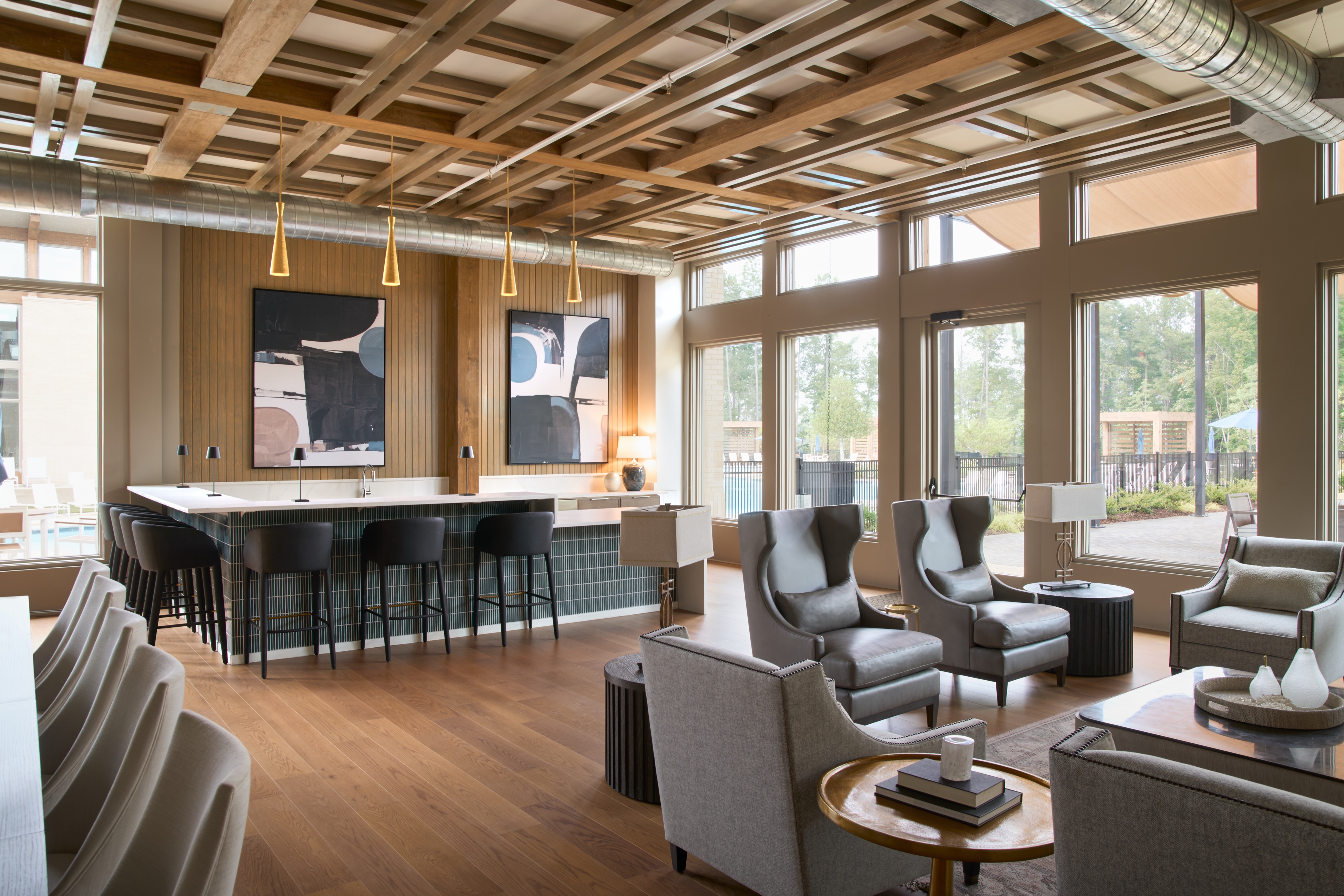 Bar and lounge seating at the Everlee Clubhouse with artwork and windows onto the pool deck, architectural photography by Omar Mohammad Studio