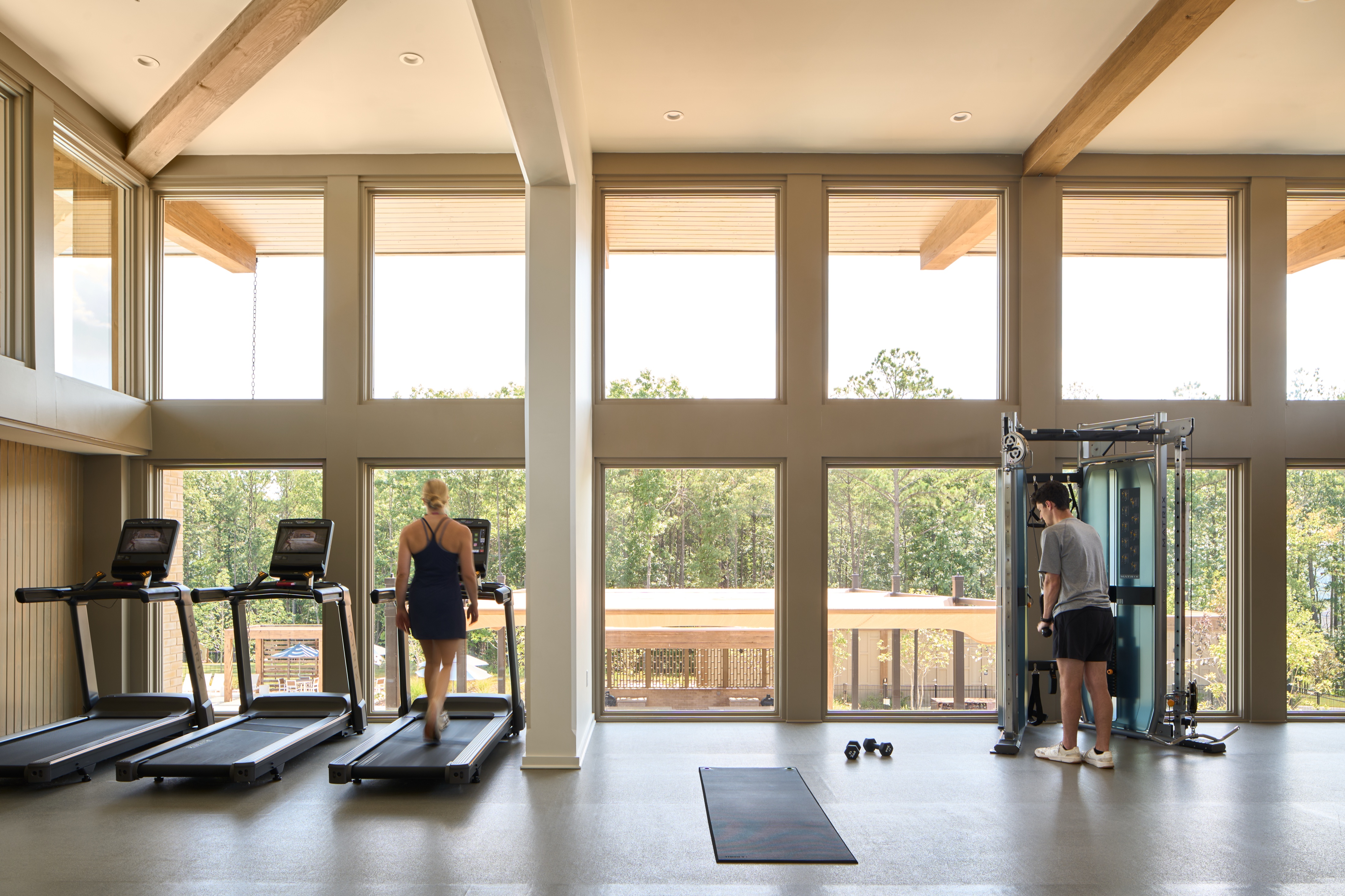 Fitness room at the Everlee Clubhouse with treadmills facing full height windows onto the woods, photographed by Omar Mohammad Studio
