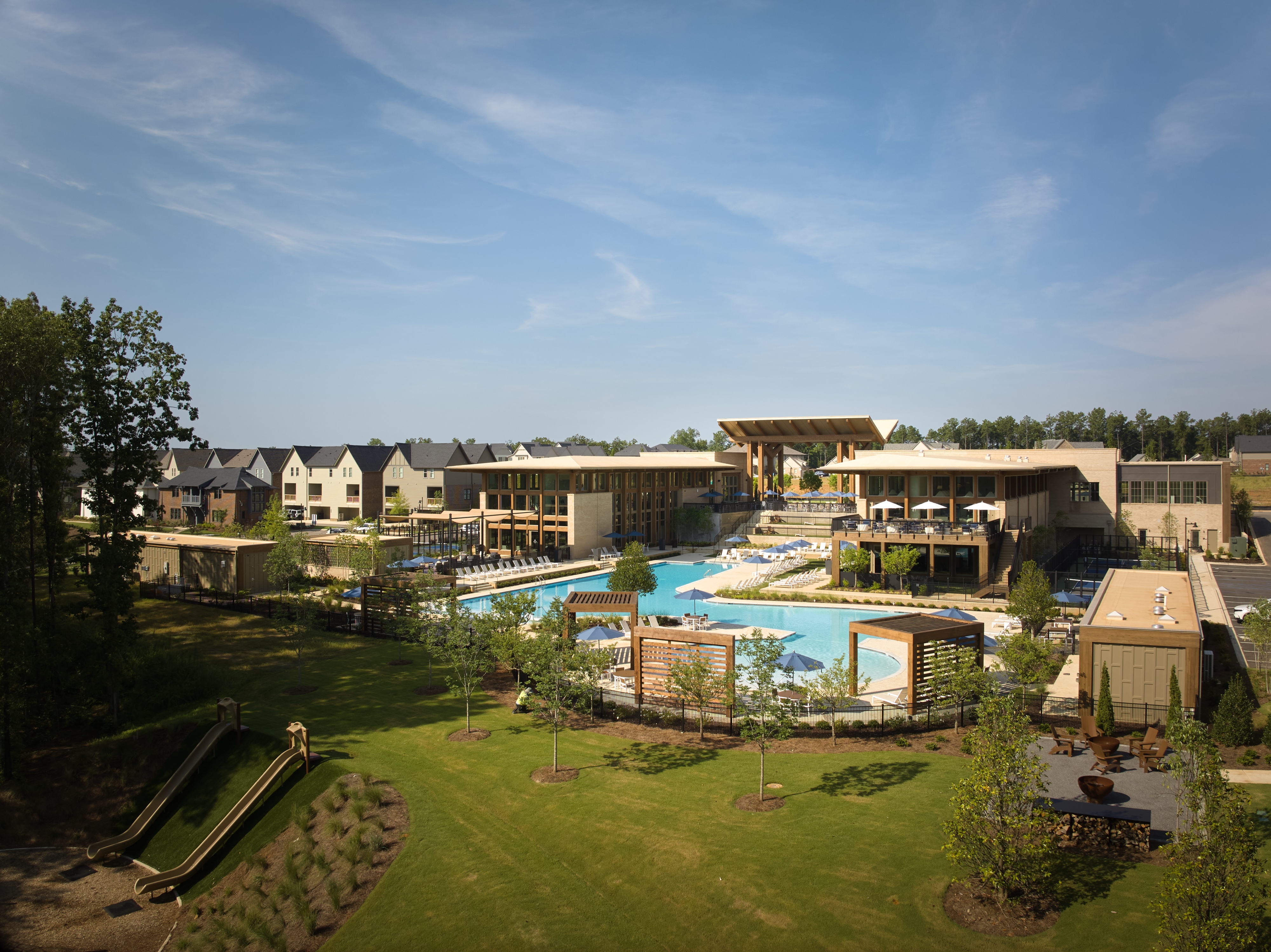 Elevated view of the Everlee Clubhouse pool and lawn with the surrounding Nequette homes beyond, architectural photography by Omar Mohammad Studio
