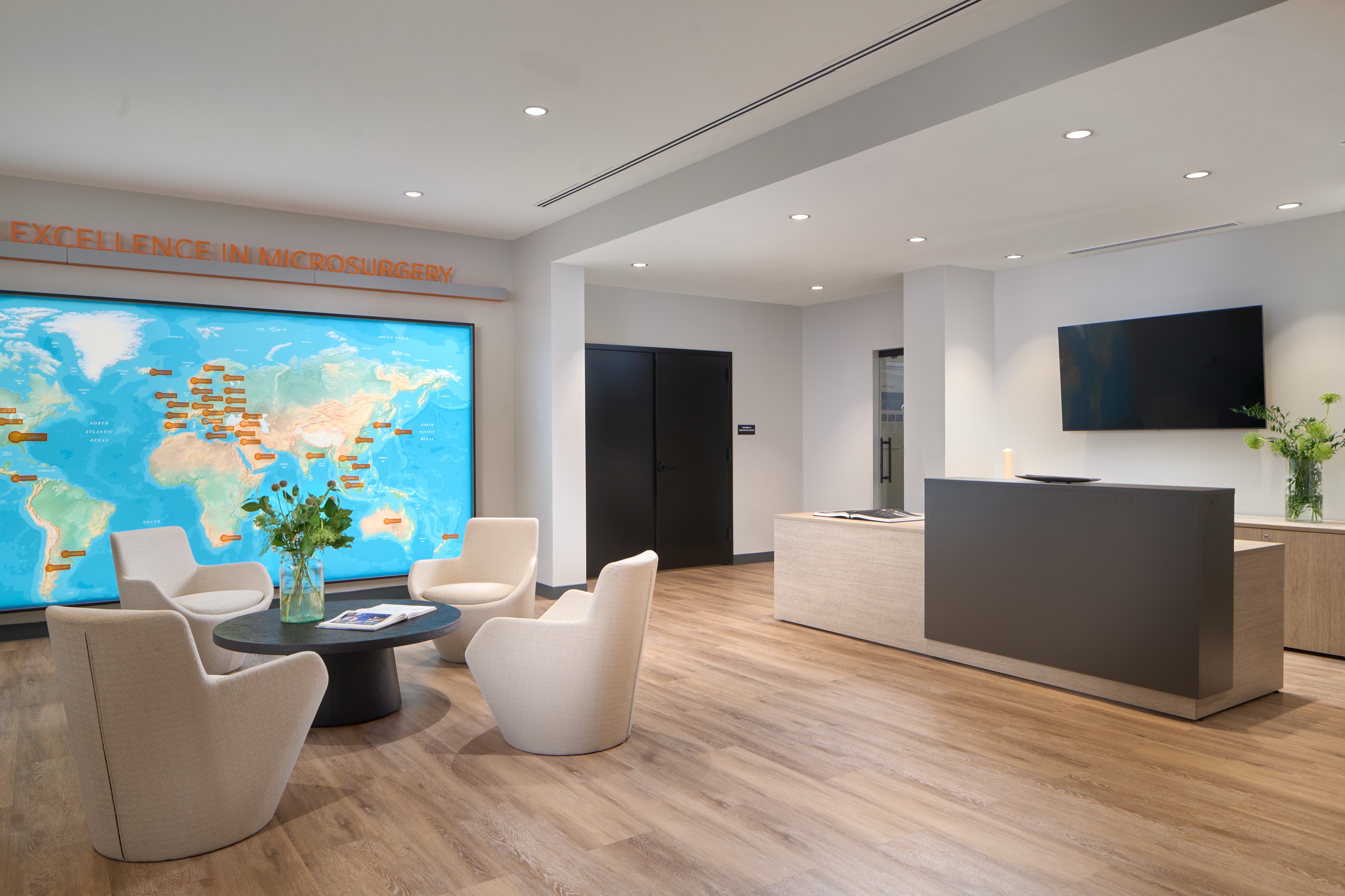 Reception desk and welcome lounge beneath a backlit world map, workplace photography by Omar Mohammad Studio