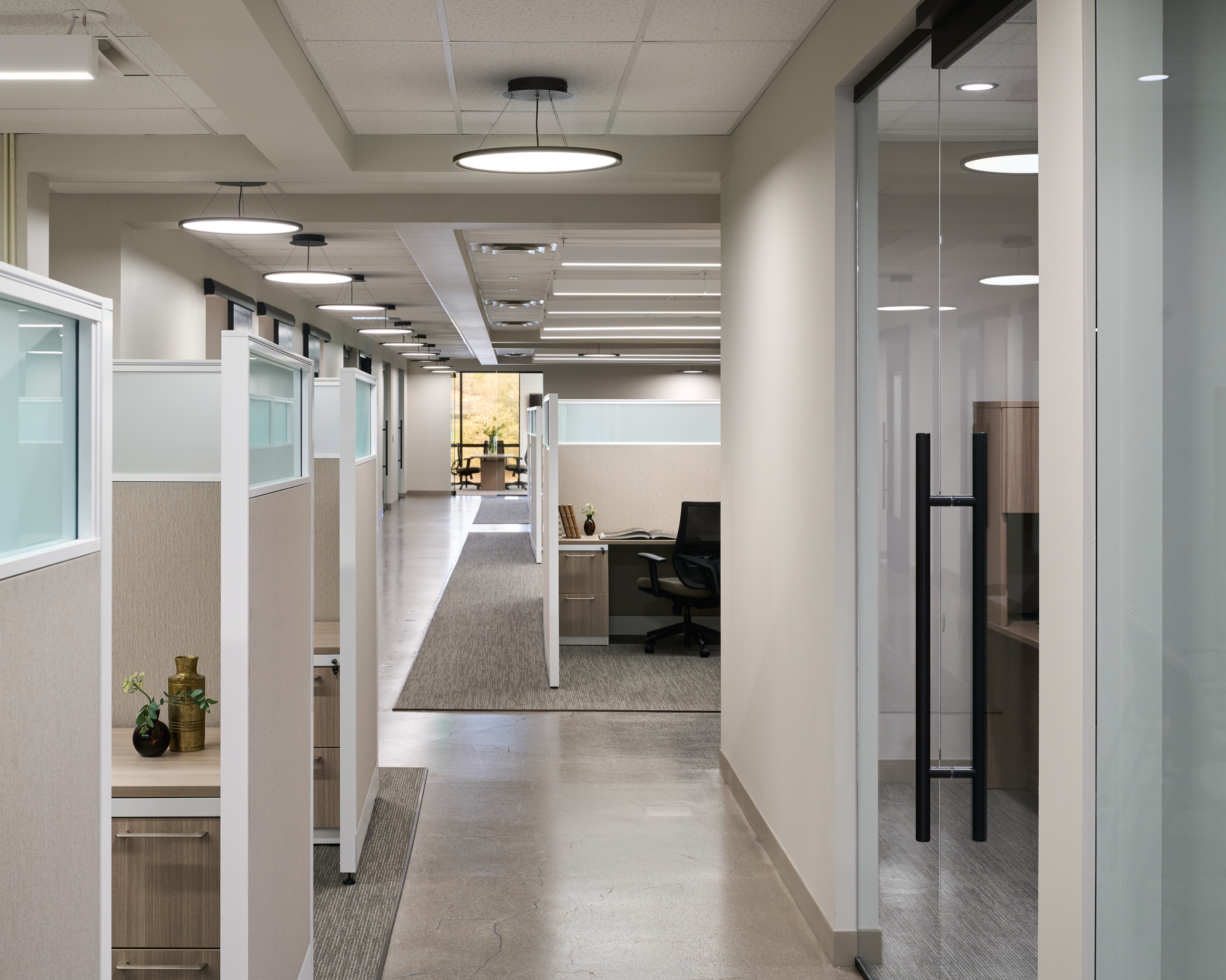 Workstation corridor with glass fronted private offices and drum pendants, workplace photography by Omar Mohammad Studio
