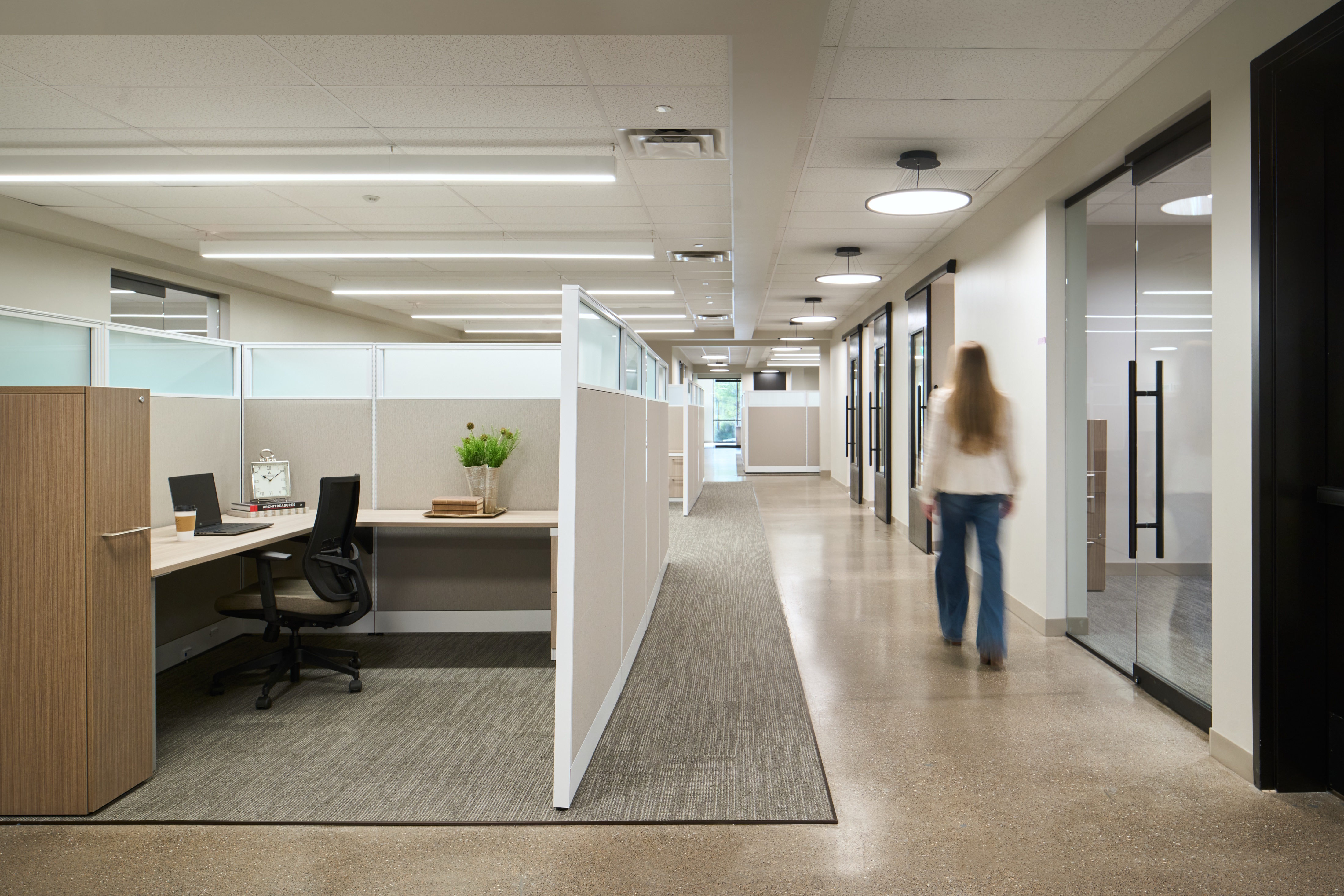 Open plan workstations along a polished concrete circulation spine, workplace photography by Omar Mohammad Studio
