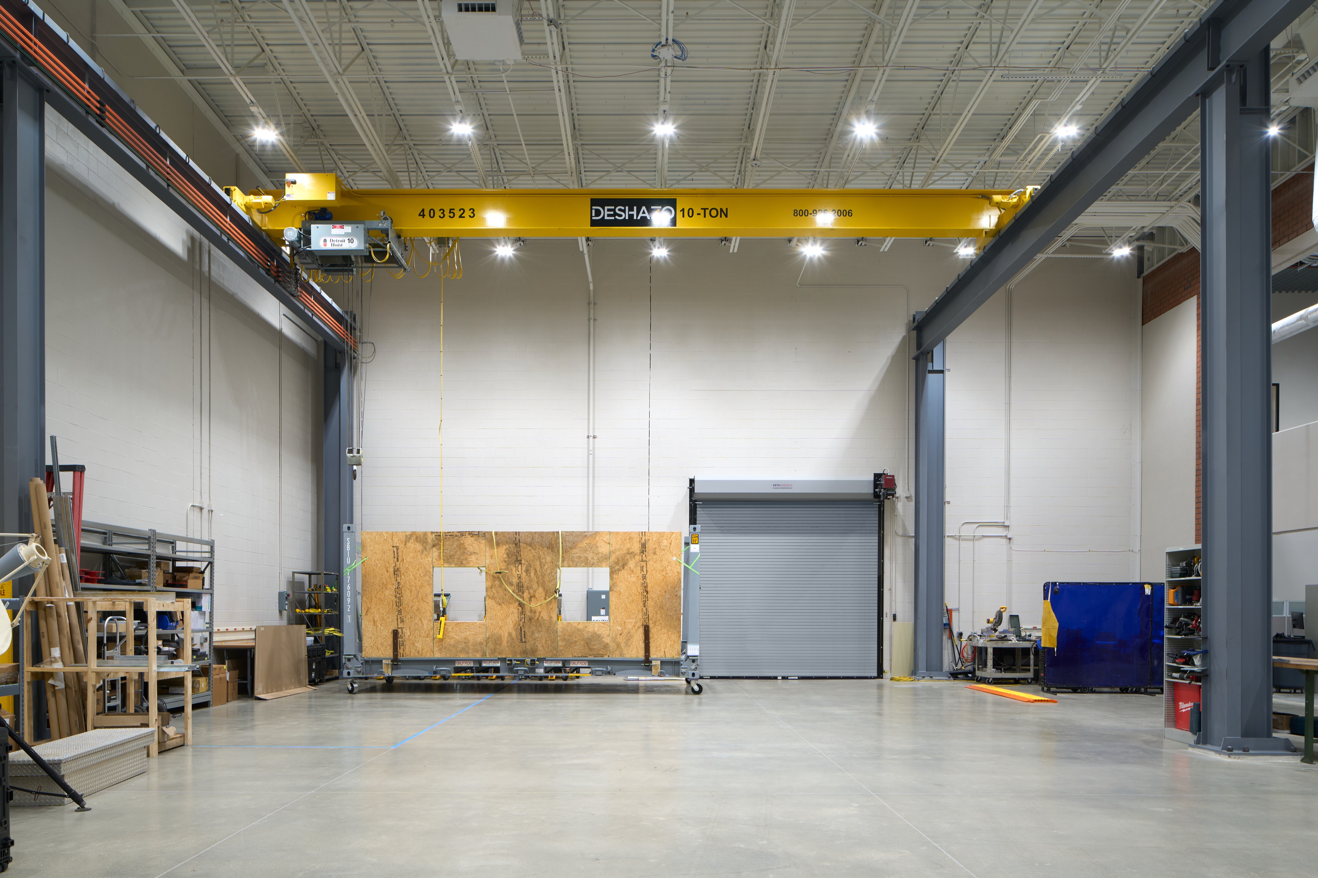 Fabrication shop bay with overhead crane and roll up door, industrial workplace photography by Omar Mohammad Studio