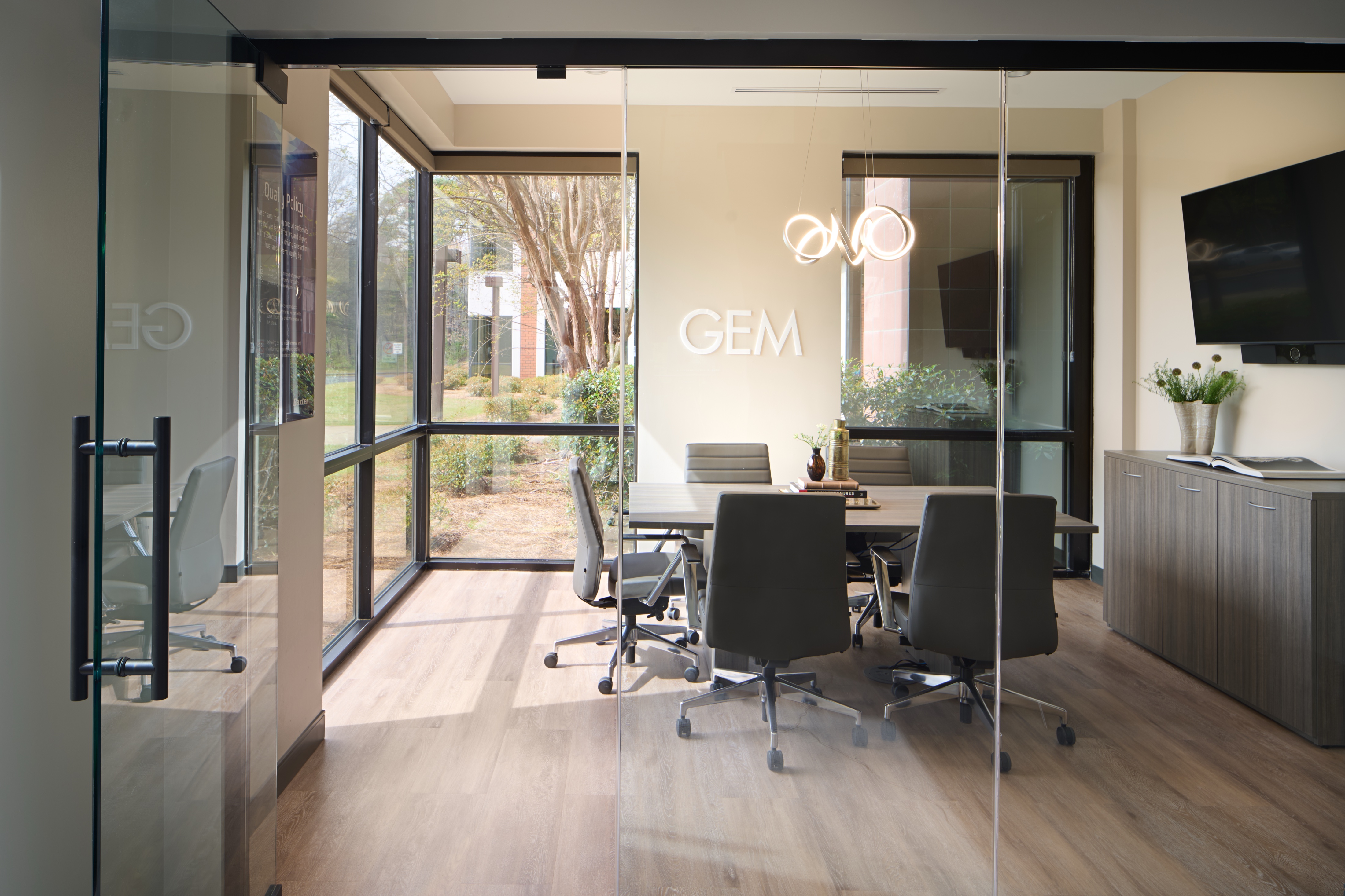 Glass walled GEM conference room opening onto a landscaped courtyard, workplace photography by Omar Mohammad Studio