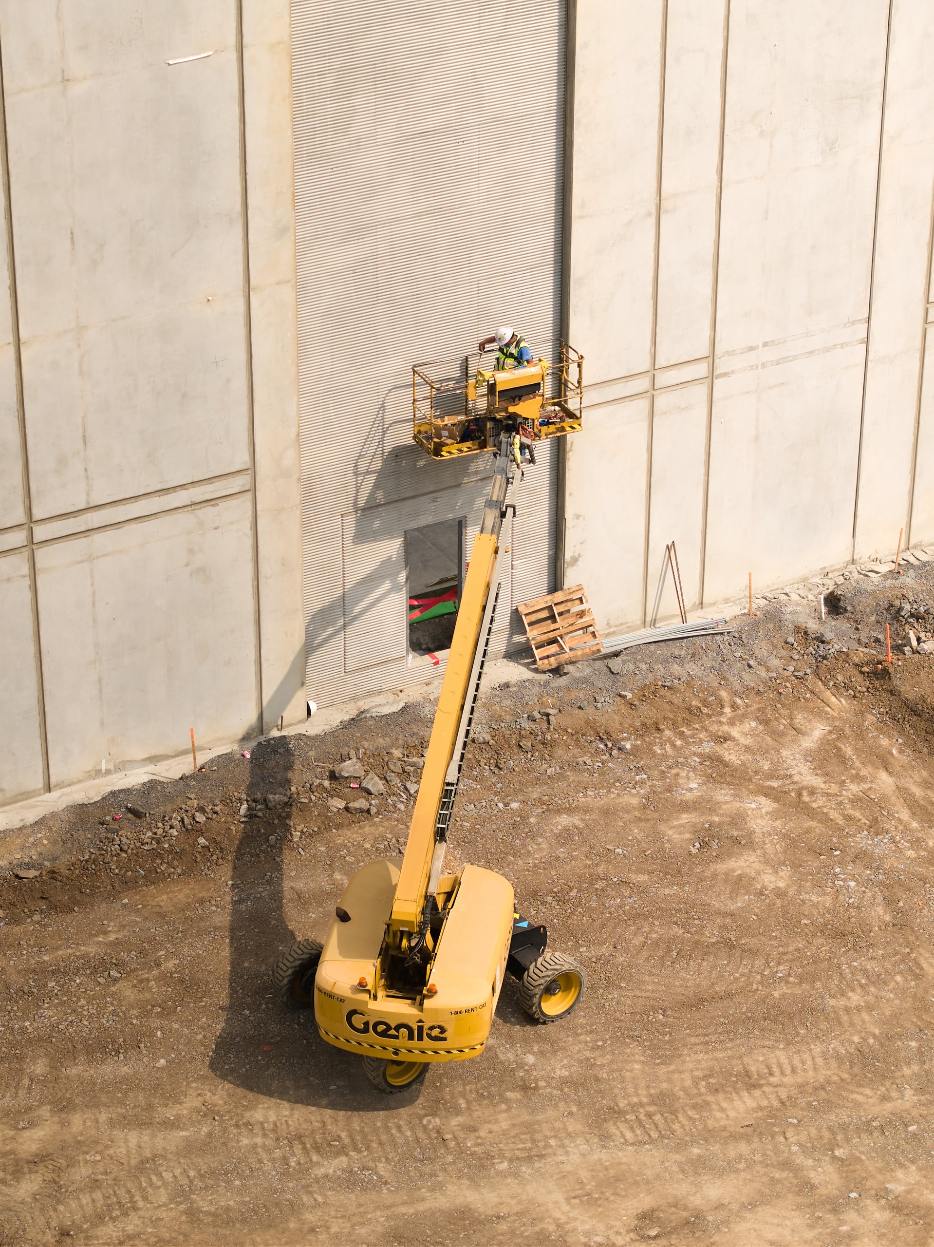 Boom lift against the tilt-up concrete wall at Hermitage Steel Erection, construction photography by Omar Mohammad Studio