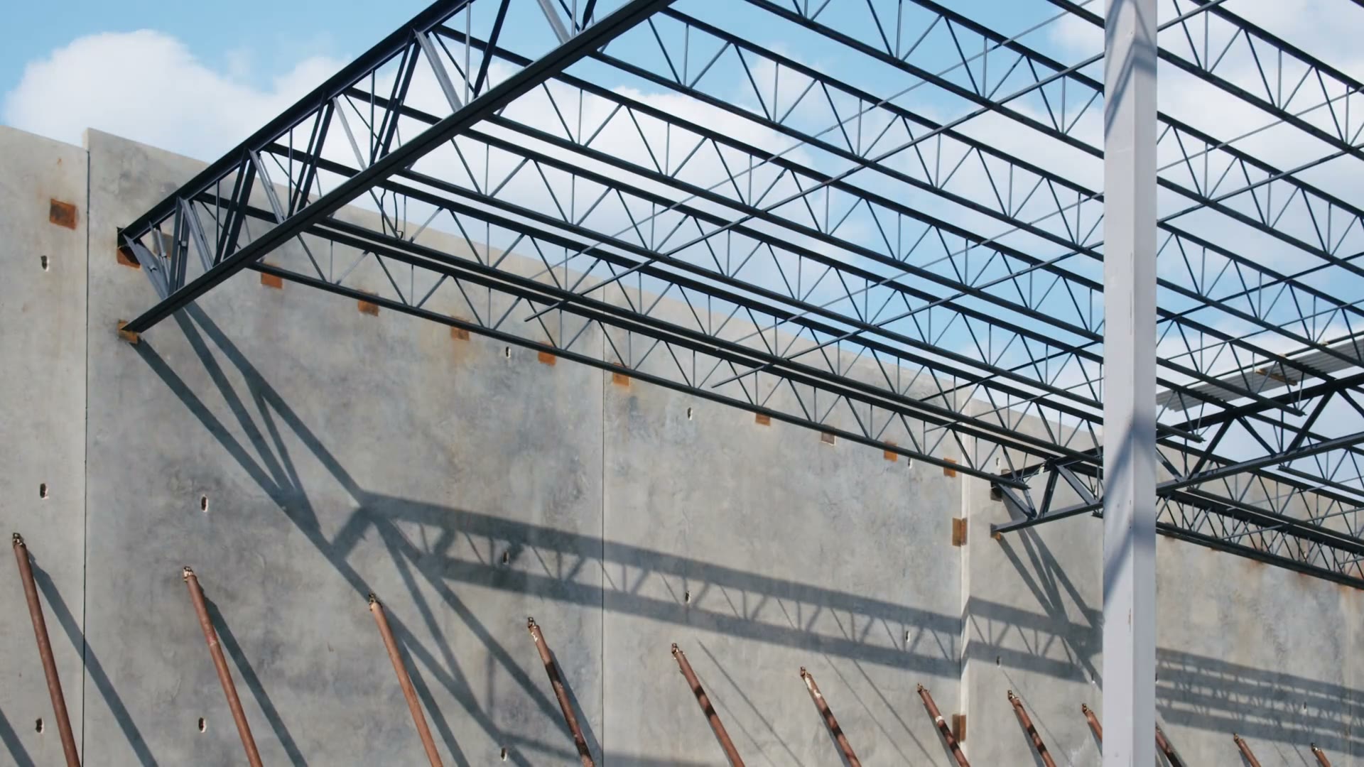 Video frame of open-web roof joists set across the tilt-up concrete walls at Hermitage, Cooper Construction