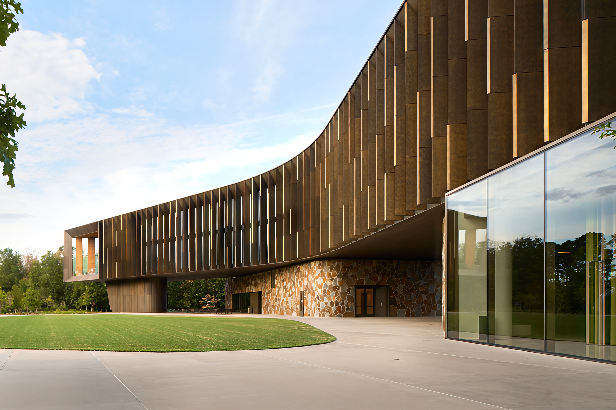 Curving timber screen above a lawn and stone walls at Heartland Whole Health Institute, architectural photography by Omar Mohammad Studio