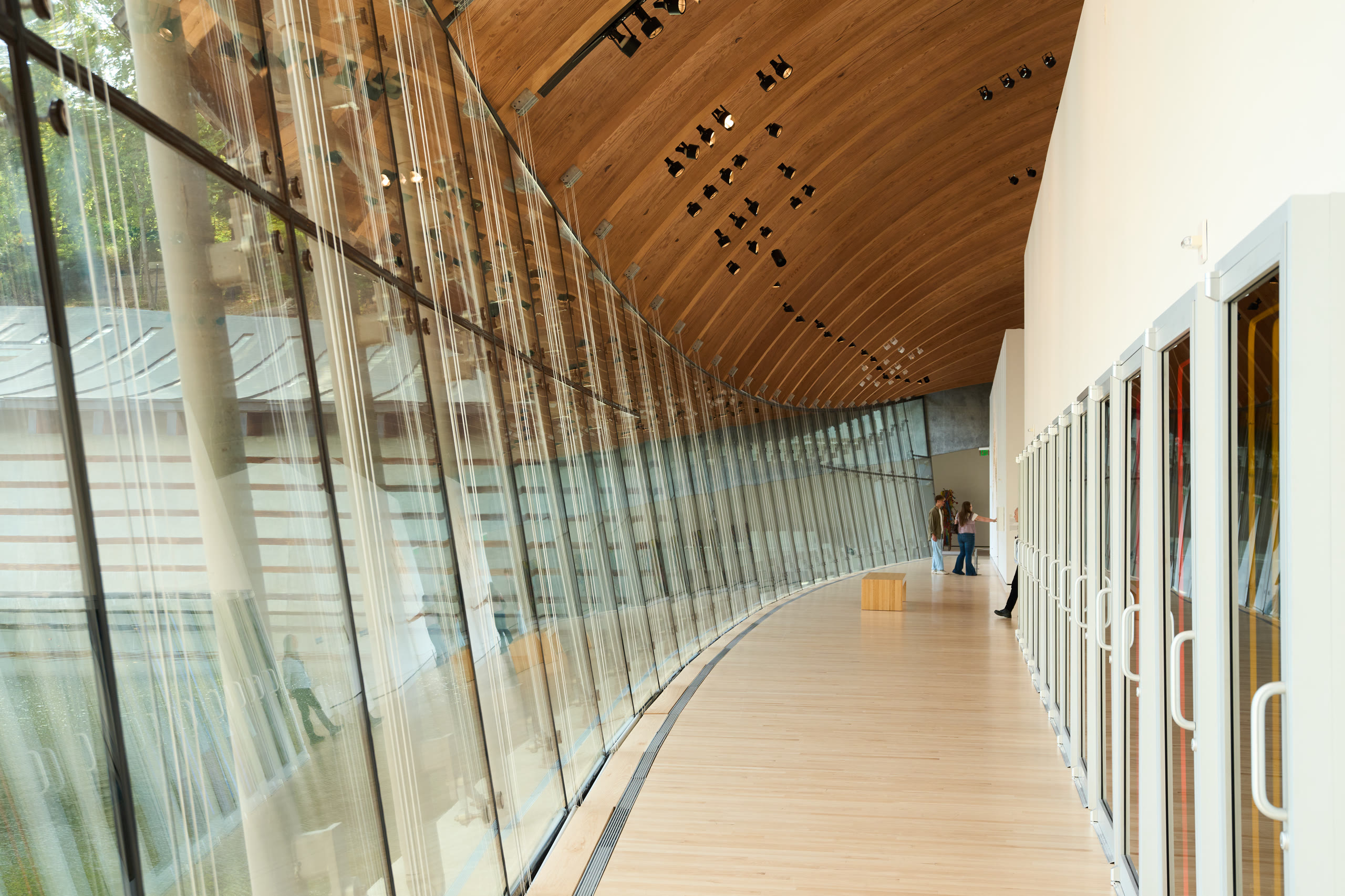 Glass corridor with a timber ceiling along the water at Crystal Bridges Museum of American Art, architectural photography by Omar Mohammad Studio