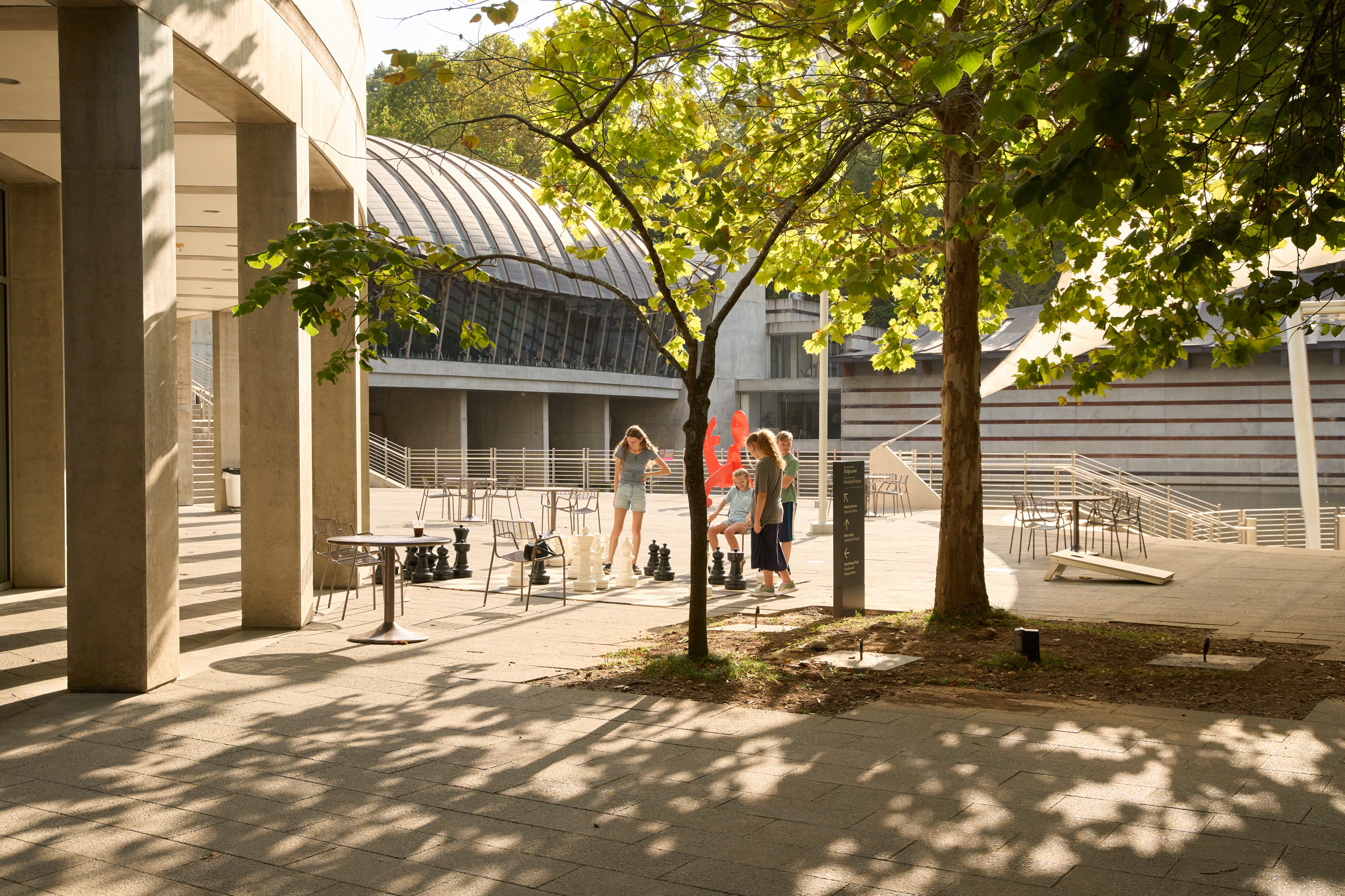Shaded courtyard with visitors under the trees at Crystal Bridges Museum of American Art, architectural photography by Omar Mohammad Studio