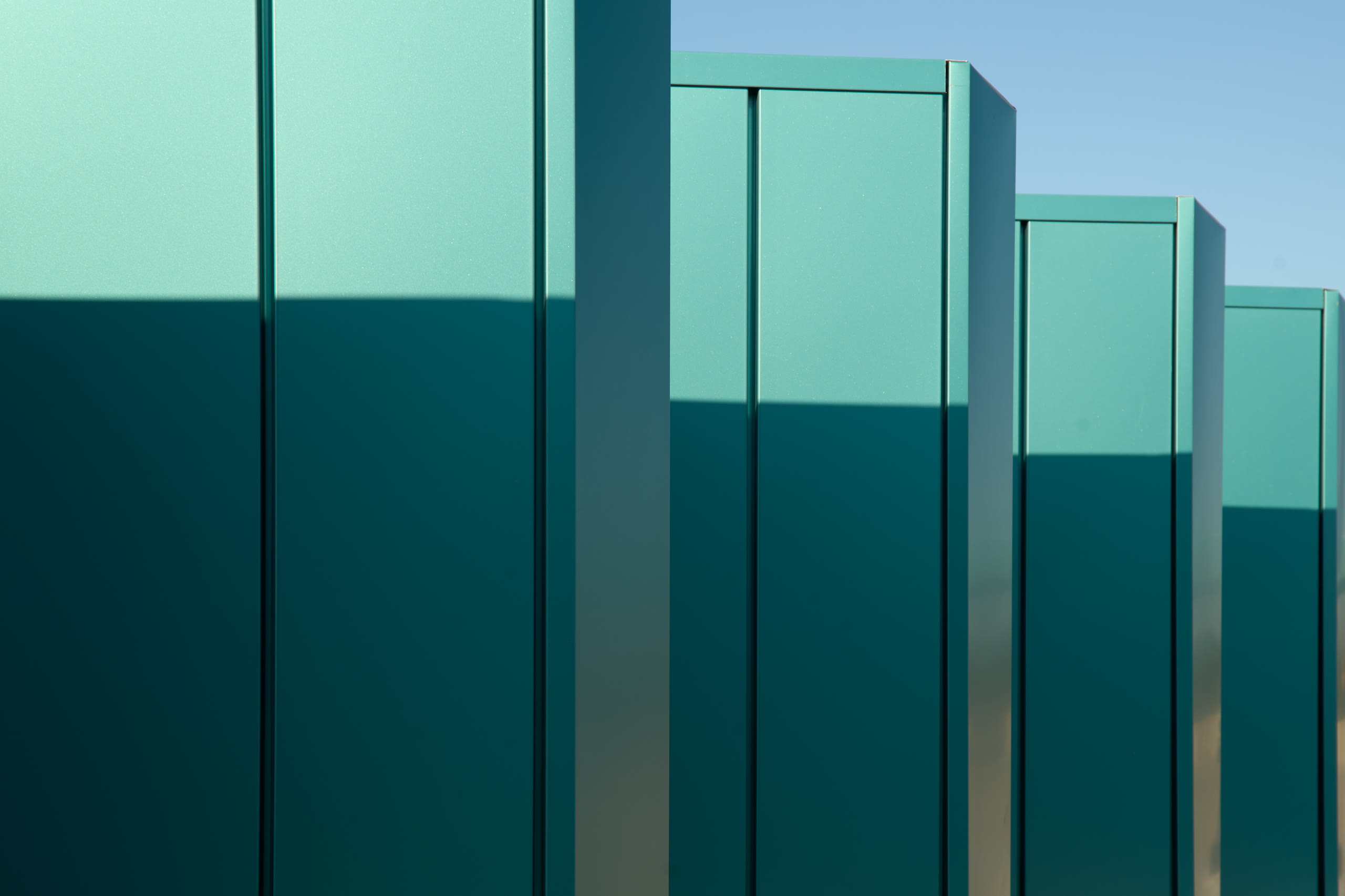 Teal fin panels catching the sun at the Crystal Bridges parking deck, architectural photography by Omar Mohammad Studio