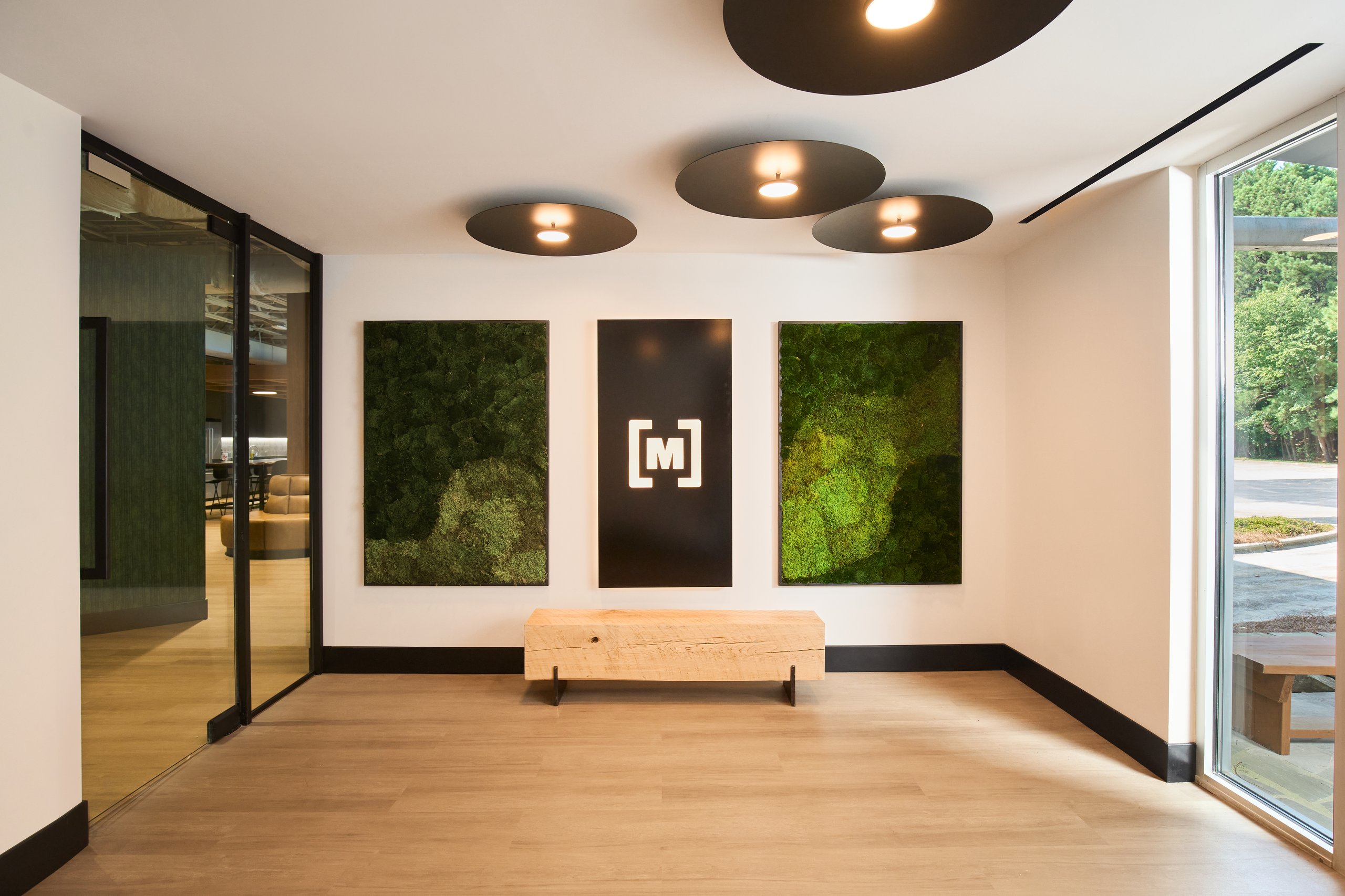 Moss wall with the Moultrie mark in the office entry, interior photography by Omar Mohammad Studio