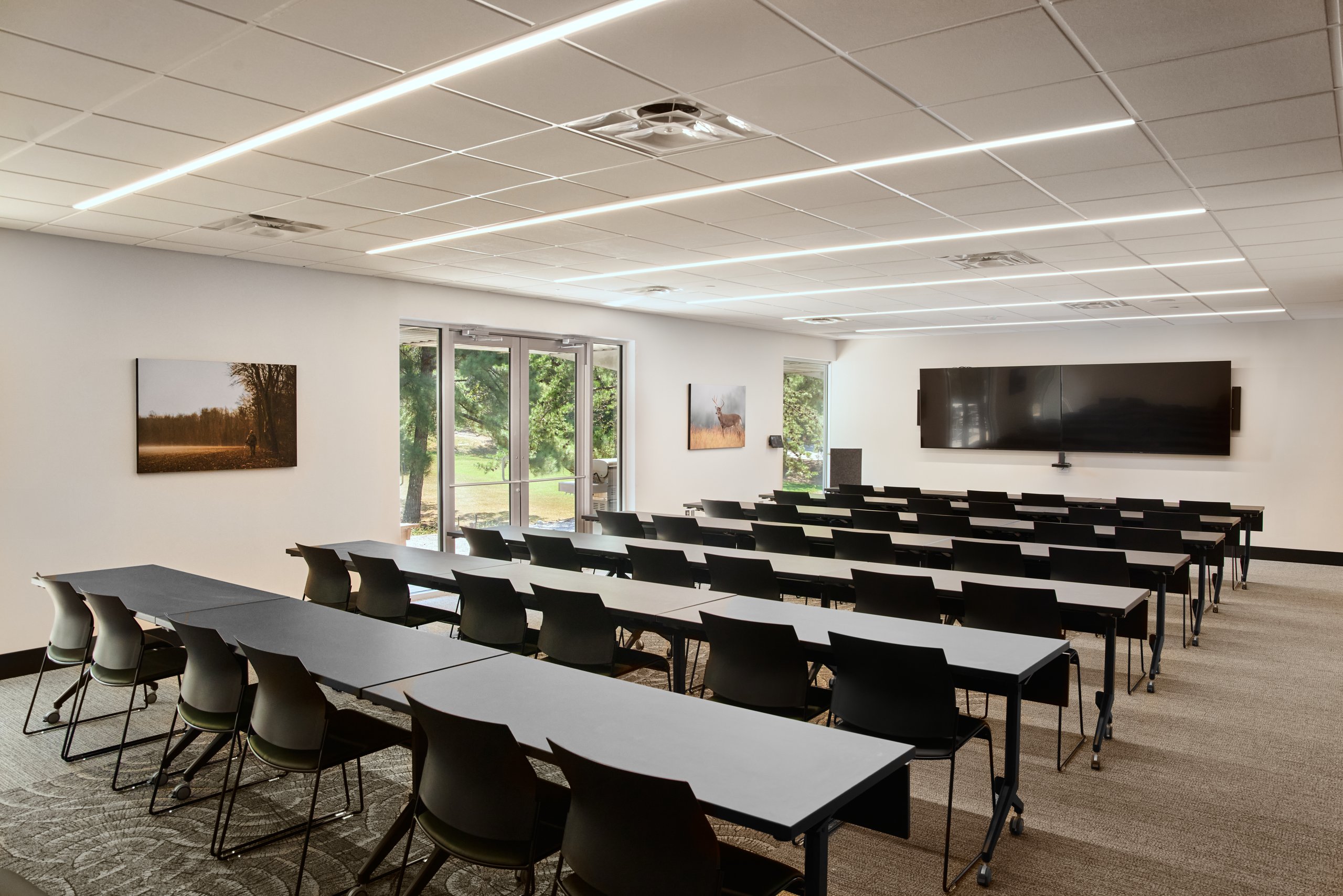 Training room with rows of tables and a wall of windows at the Moultrie office
