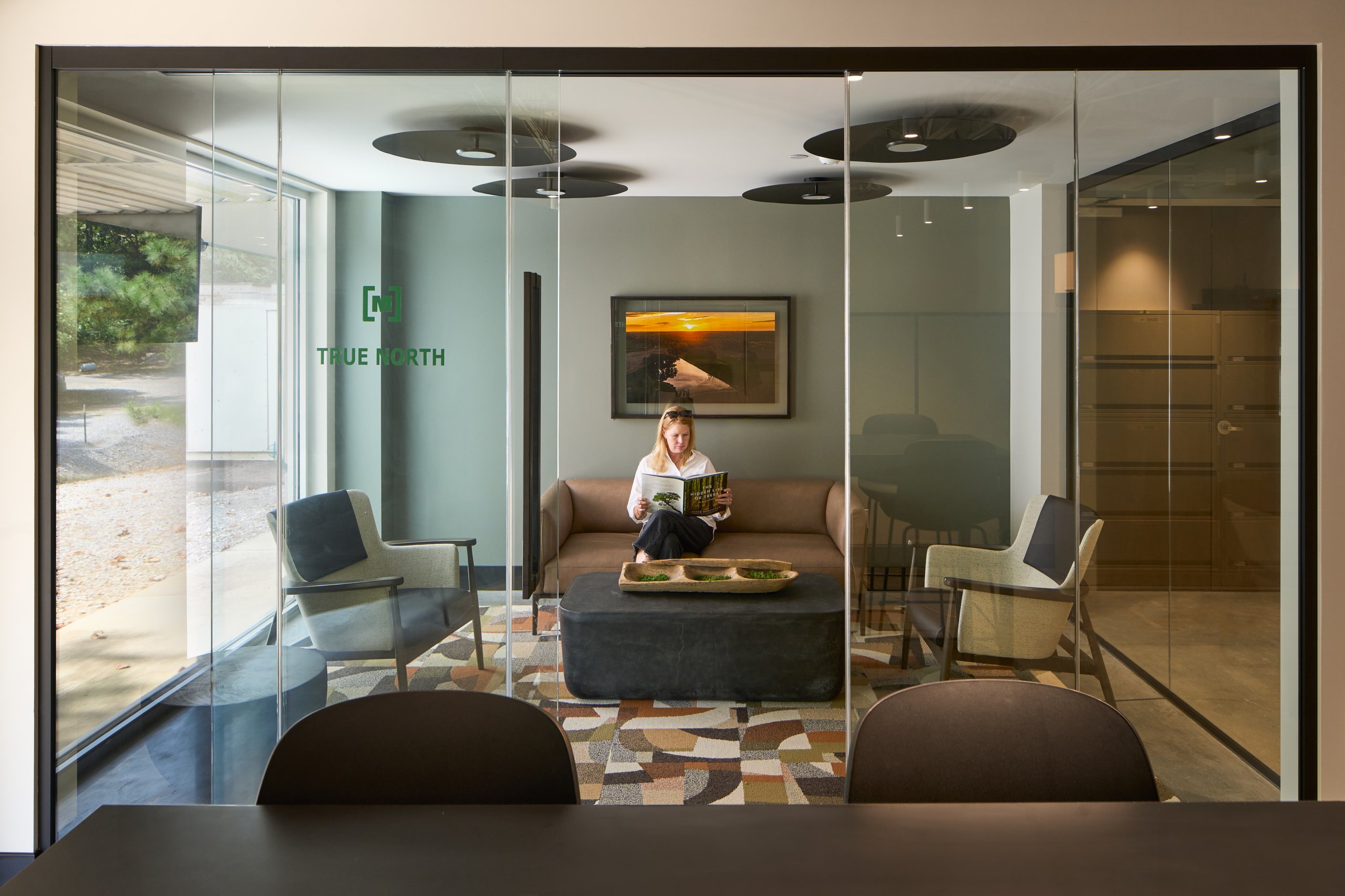 Glass office with a sofa and lounge seating at the Moultrie office