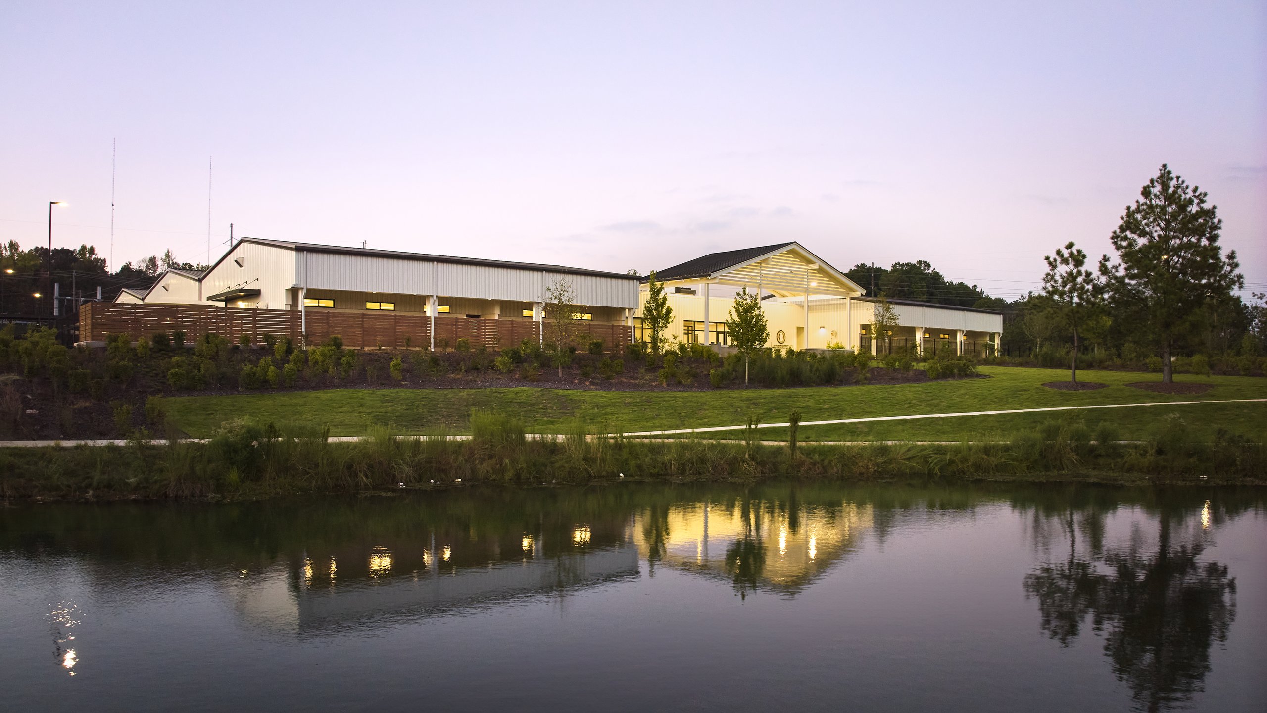 Jefferson County Animal Control at dusk, the lit buildings reflected in the pond, photographed by Omar Mohammad Studio