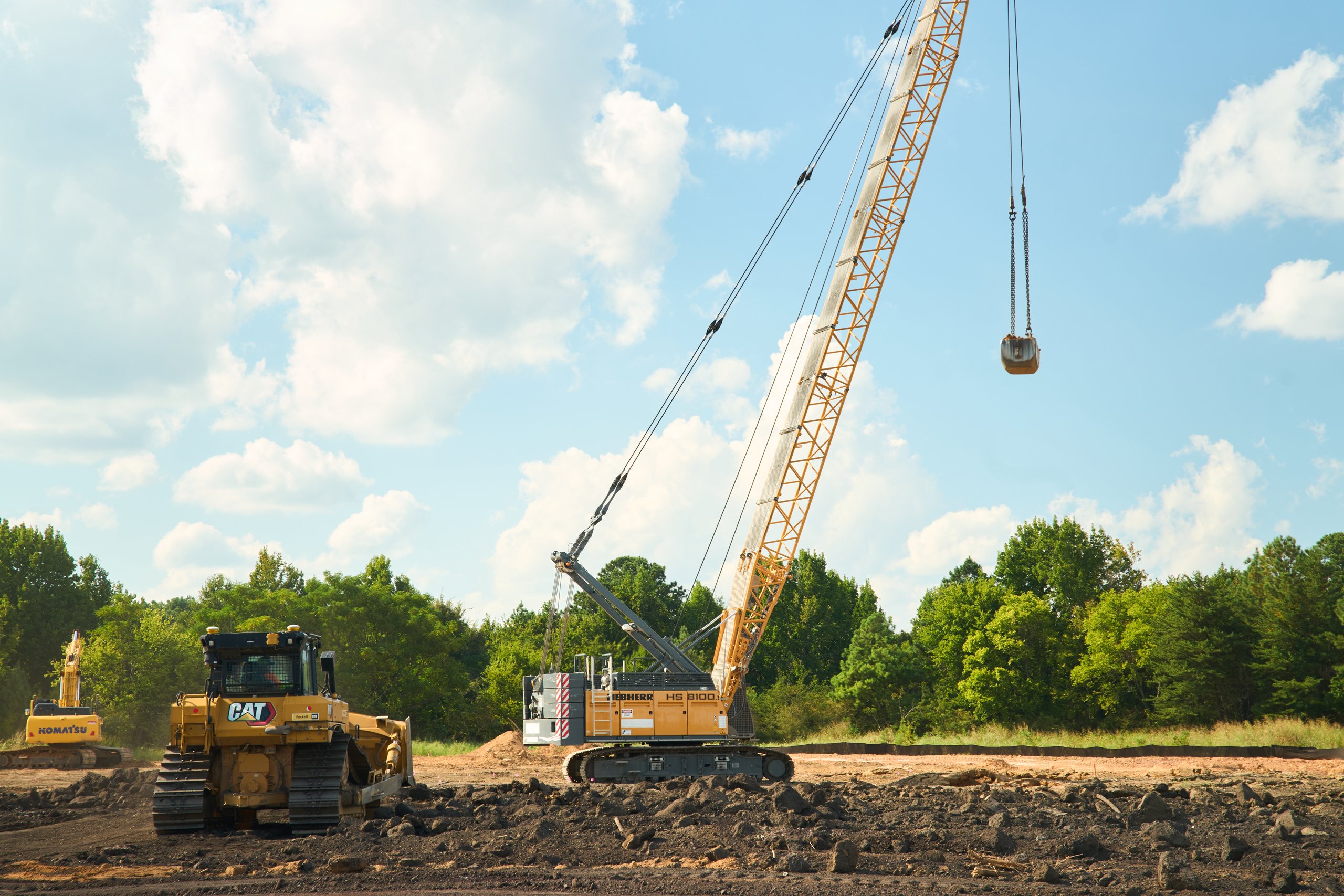 Crawler crane lifting a compaction weight beside a dozer on the Coalburg site, construction photography by Omar Mohammad Studio