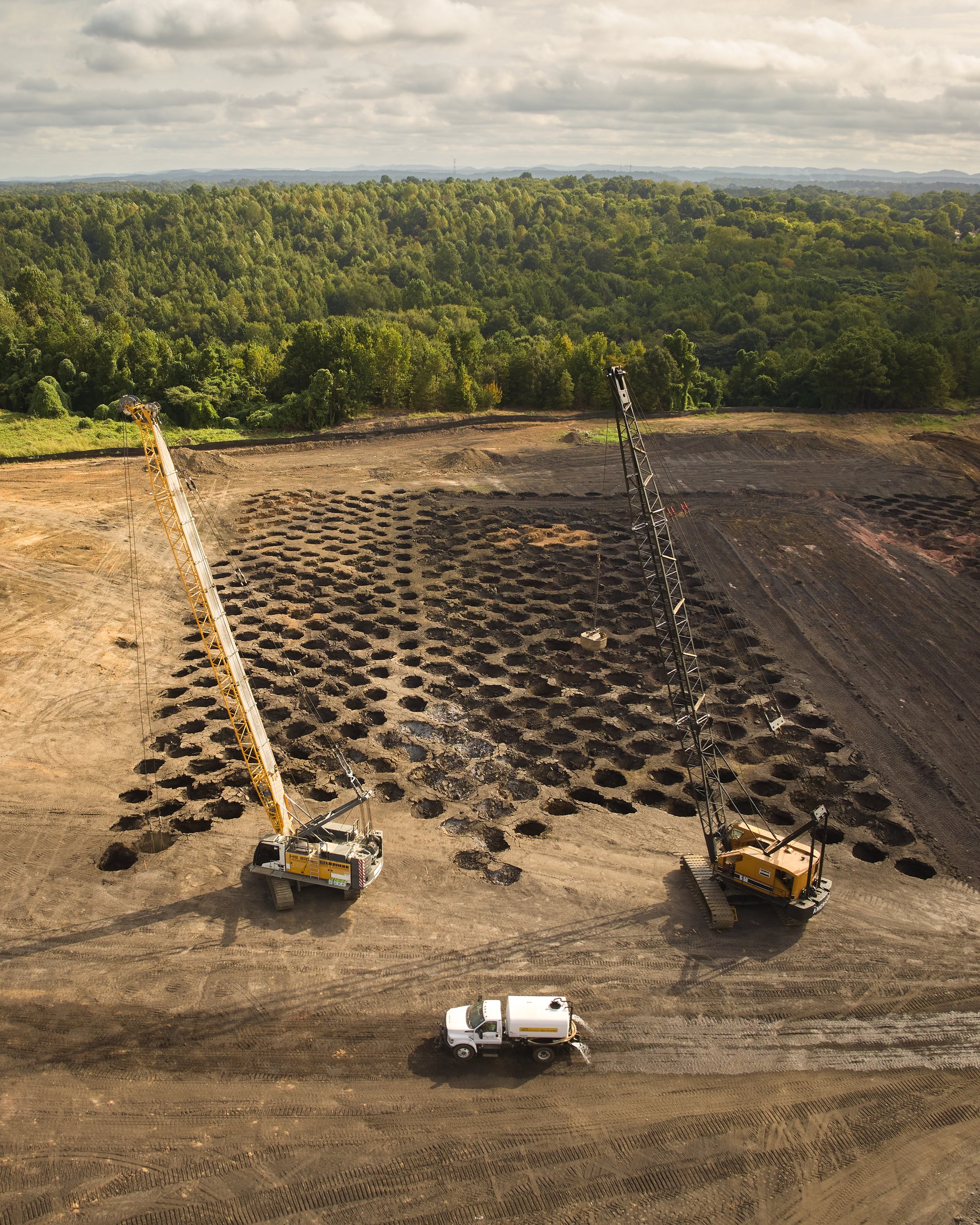 Overhead view of two cranes working a grid of compaction craters at the Coalburg site for Cooper Construction, photographed by Omar Mohammad Studio