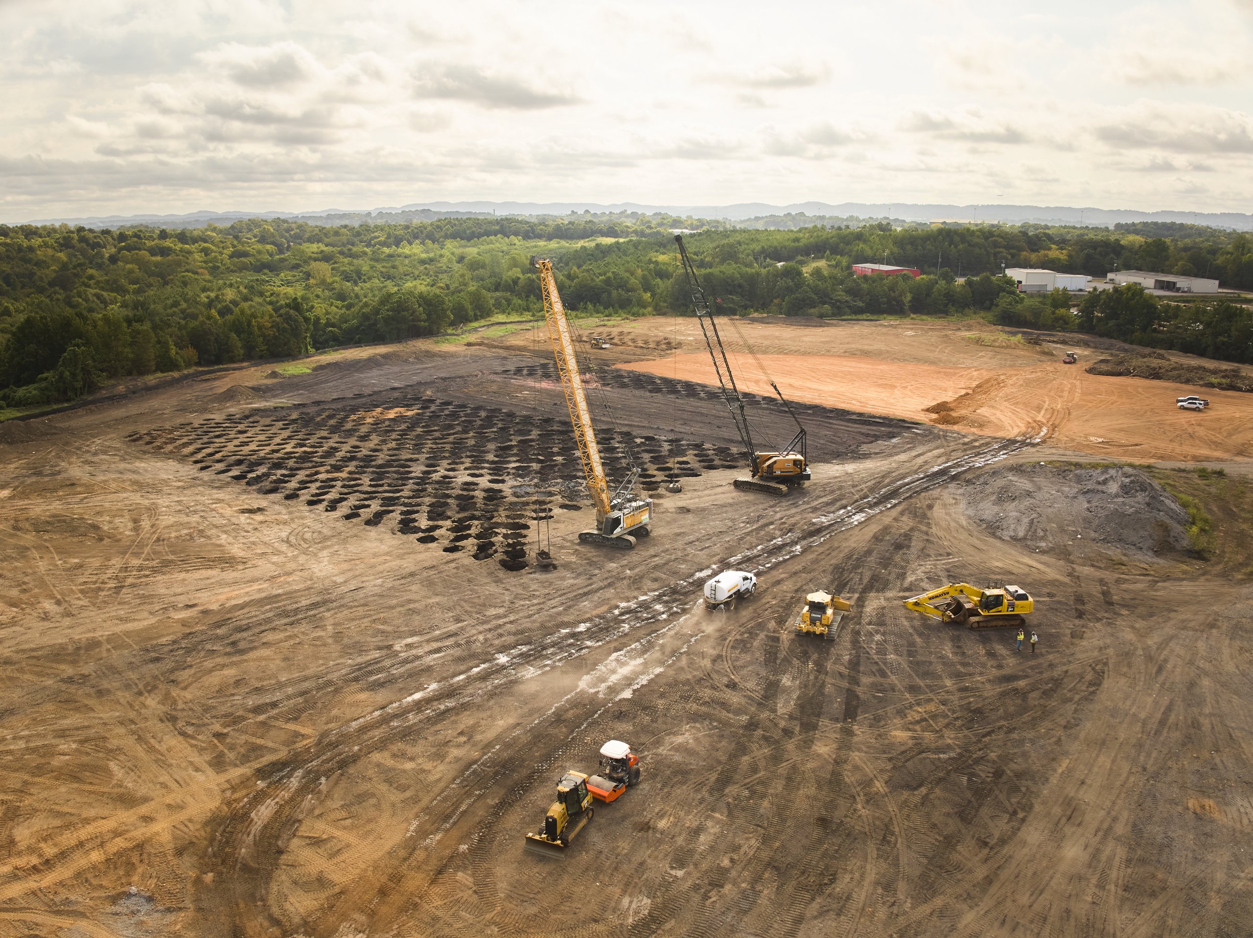 Wide aerial view of cranes, dozers and rollers working the compacted Coalburg site, photographed by Omar Mohammad Studio