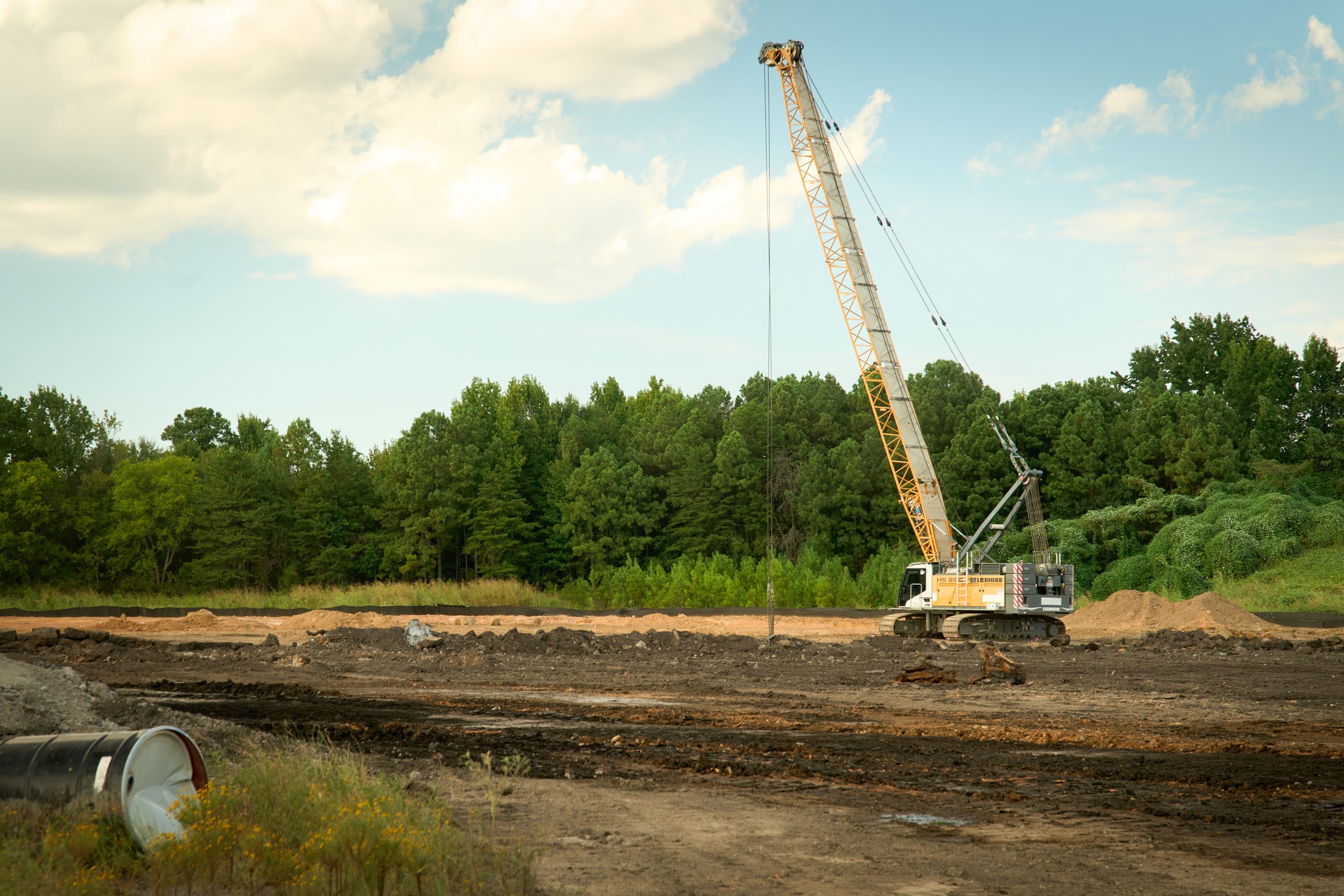 Crawler crane against the tree line at the edge of the Coalburg site, photographed by Omar Mohammad Studio