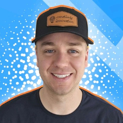 Headshot of Zeke, CEO of Creatively Innovative, a smiling man wearing a black baseball cap with an orange brim and the "Creatively Innovative" logo on a brown patch.