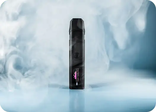 Black vape device labeled TASTEBUDZ standing upright on a blue surface surrounded by swirling vapor.