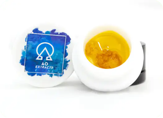 White container with blue AO Extracts logo next to an open container showing golden cannabis concentrate inside.