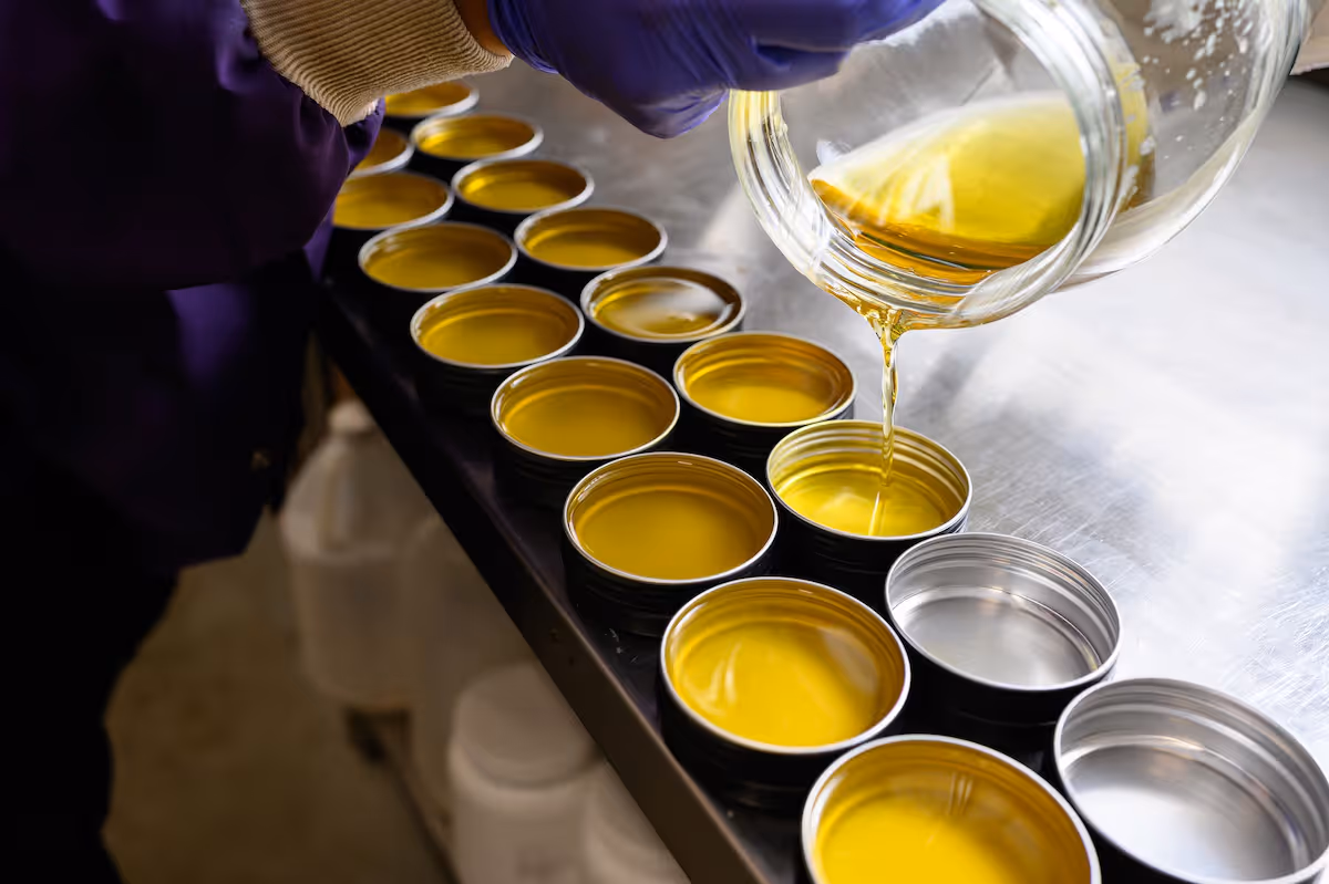 Photo of liquid CBD products being poured into individual tins