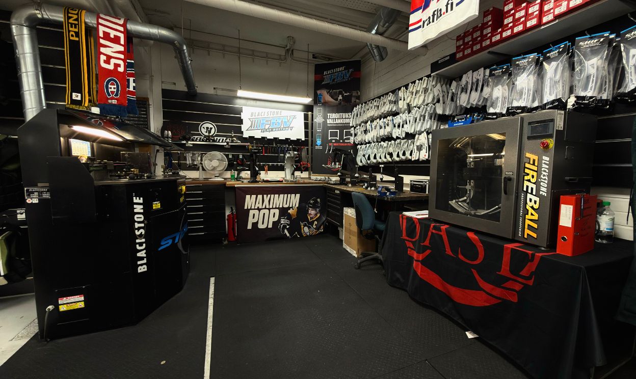 Teollinen työpaja, jossa on mustia Blackstone-laitteita, työtaso, työtuoli ja seinällä roikkuvia hansikkaita.