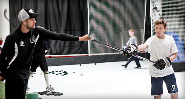 Ice Hockey Coach teaching a young hockey player