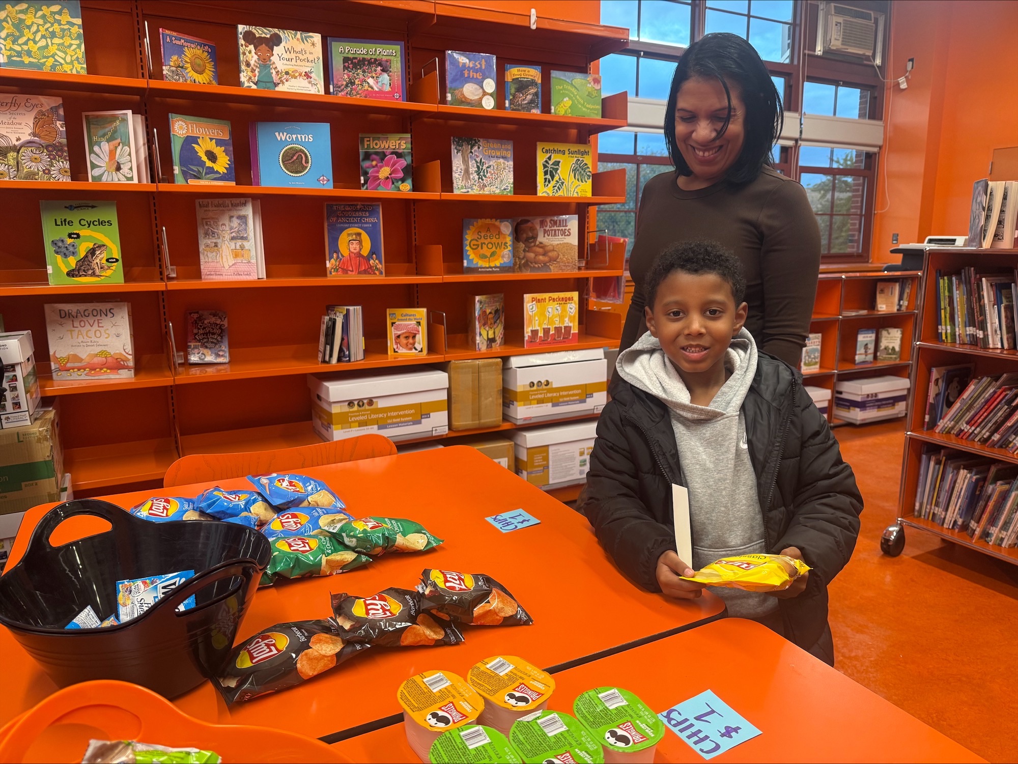 Child and adult at a snack table in library