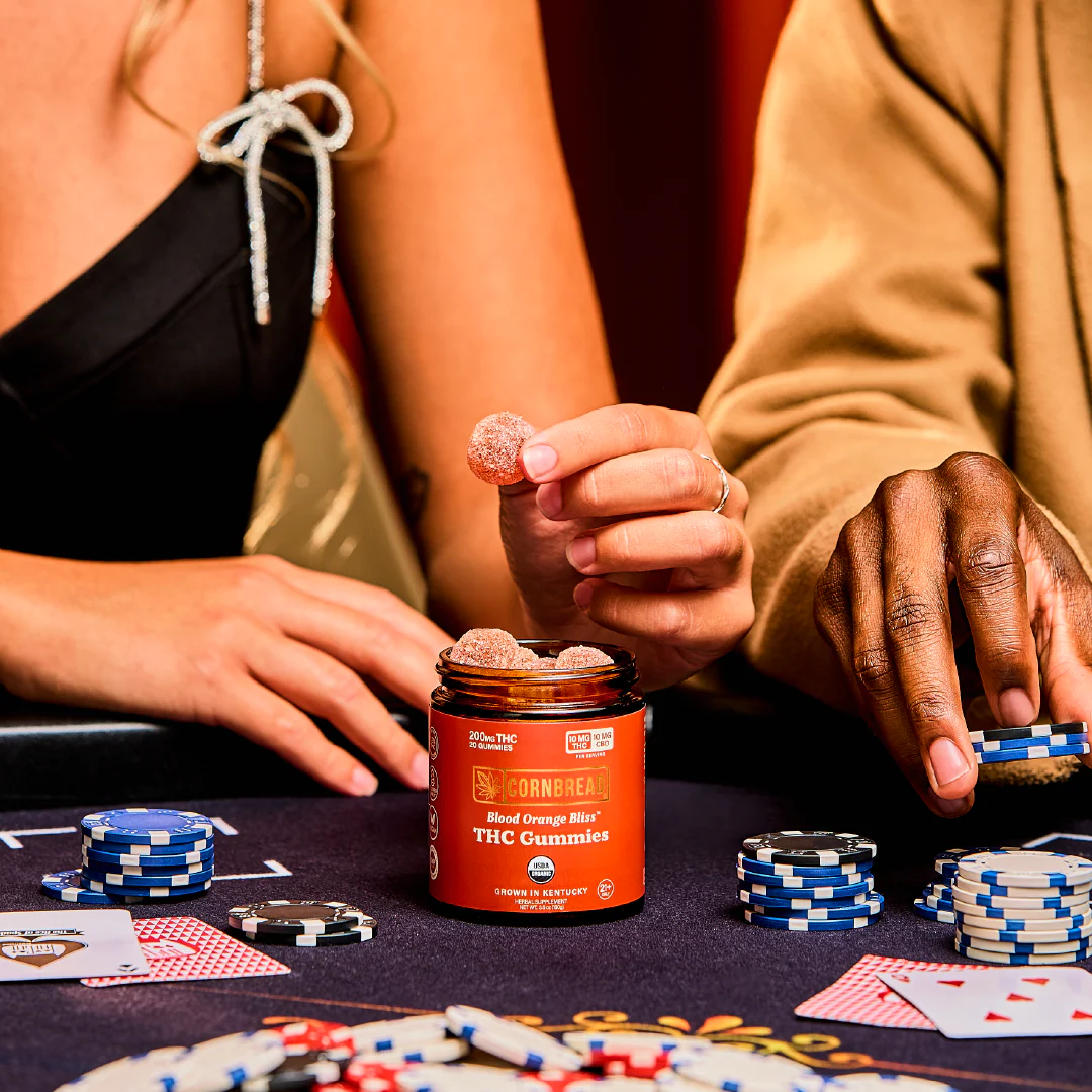 Two people ate a poker table eating gummies