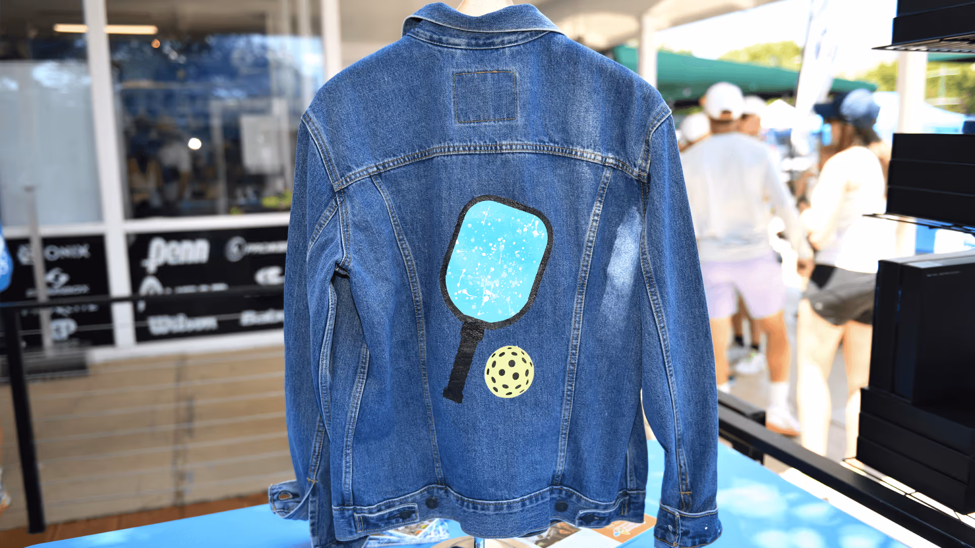A hand-painted denim jacket featuring a pickleball paddle and ball.