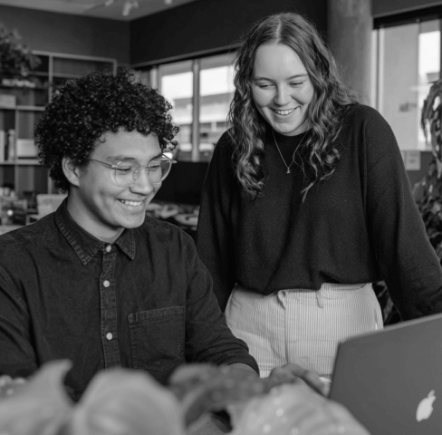 Colleagues Collaborating At Laptop In Modern Office PromptEngine Webflow Template | BRIX Template