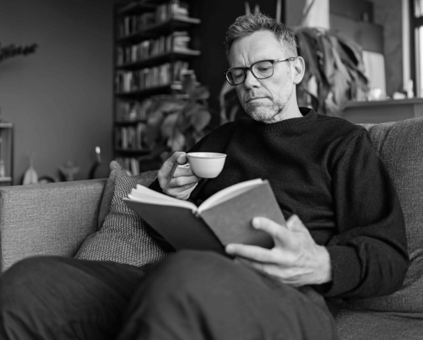 Man Reading With Coffee On Sofa PromptEngine Webflow Template | BRIX Template