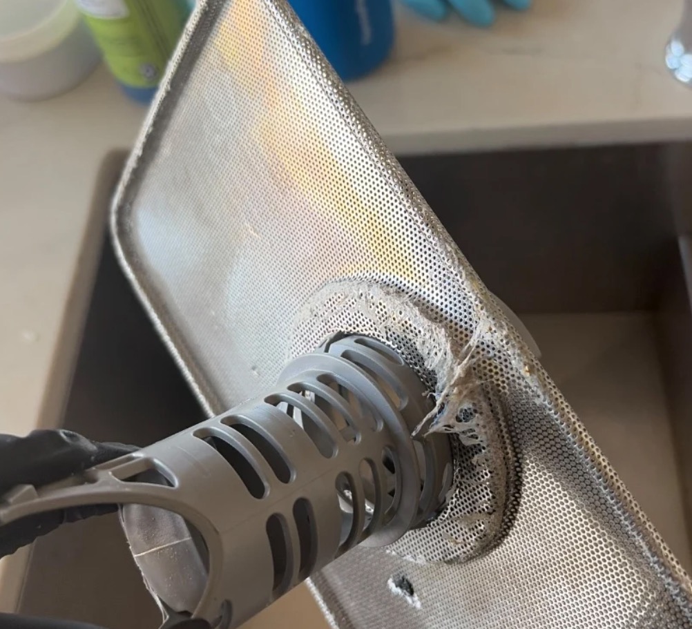 Dishwasher filter assembly with the cylindrical filter and mesh screen covered in debris