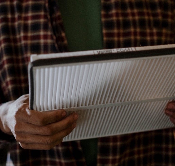 Person holding a clean replacement HVAC air filter