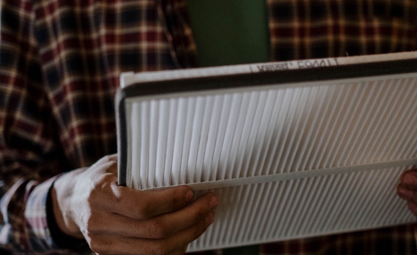 Person holding a clean replacement HVAC air filter