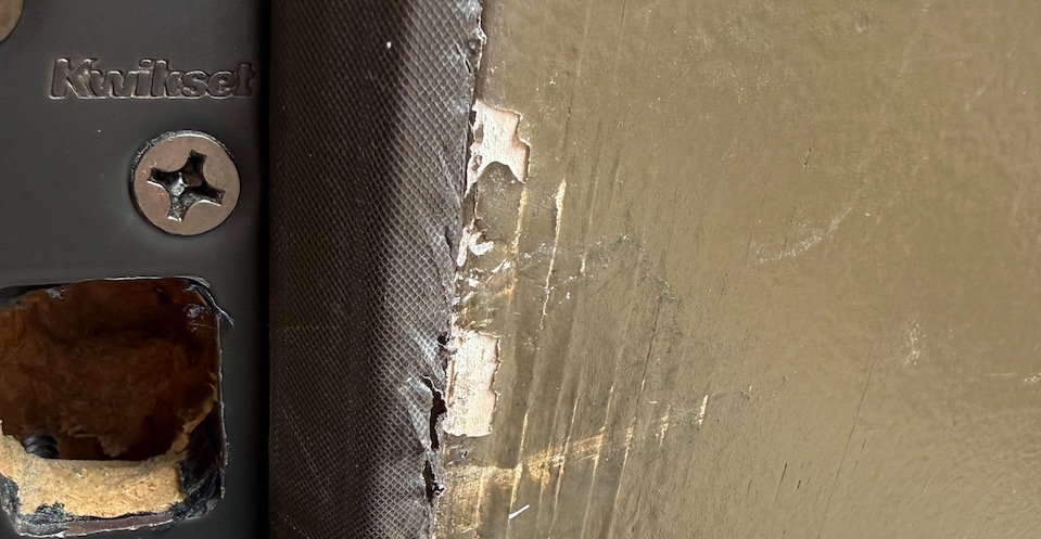 Worn weather stripping along an exterior door frame