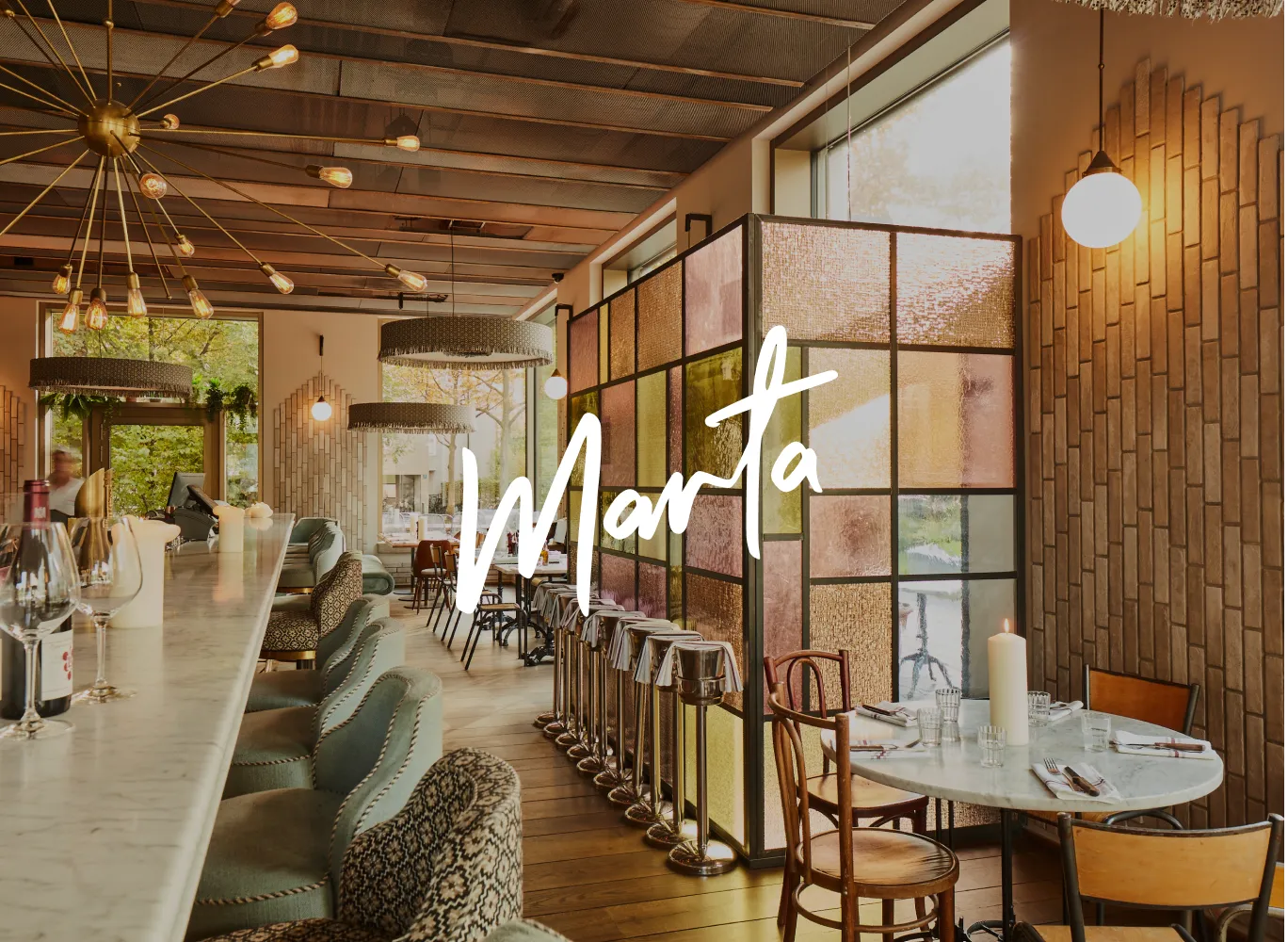 Weißes Marta Logo auf Innenaufnahme des Marta Restaurants