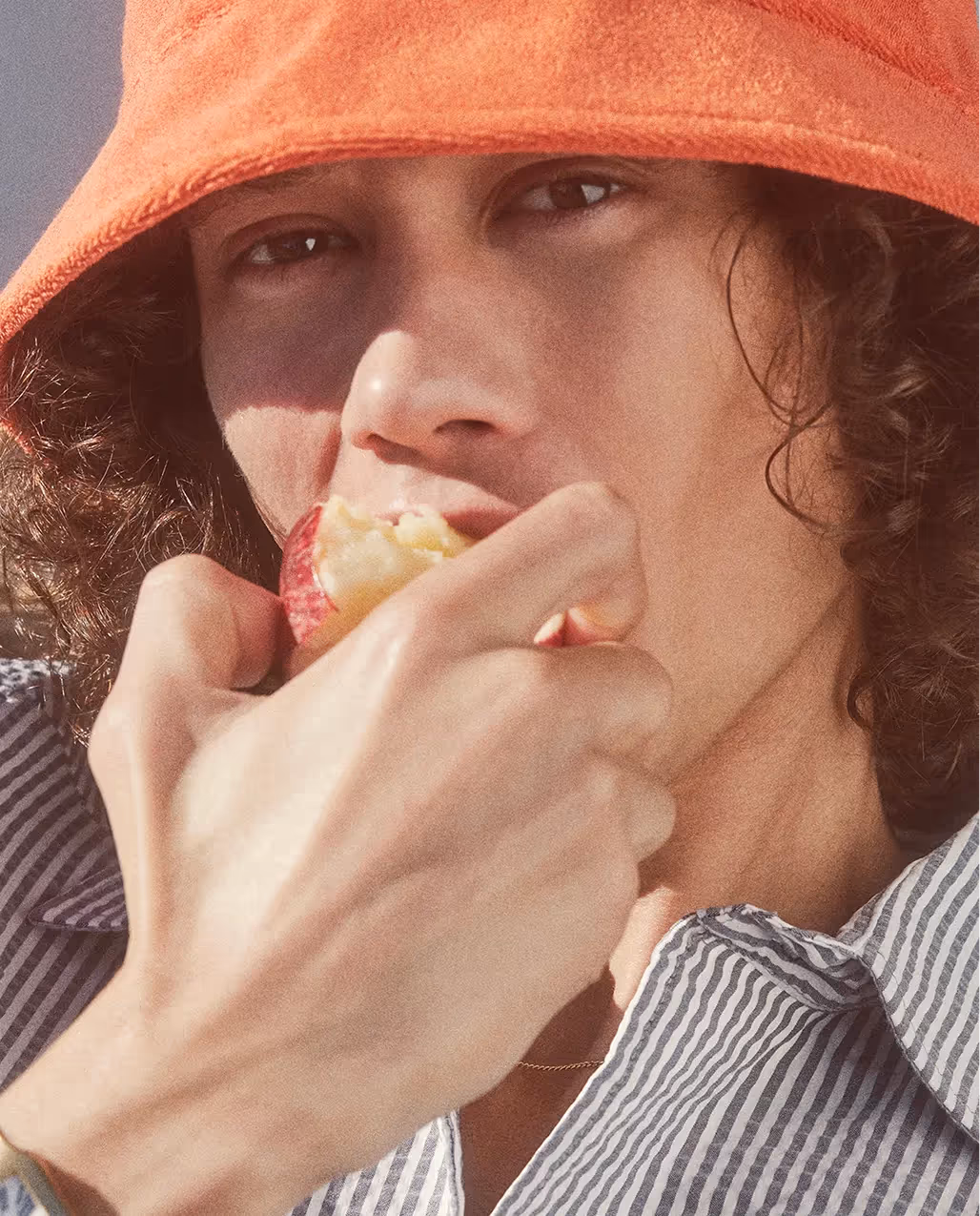 Mann mit orangefarbenem Hut im sommerlichen Editorial-Stil der 04651 Kampagne